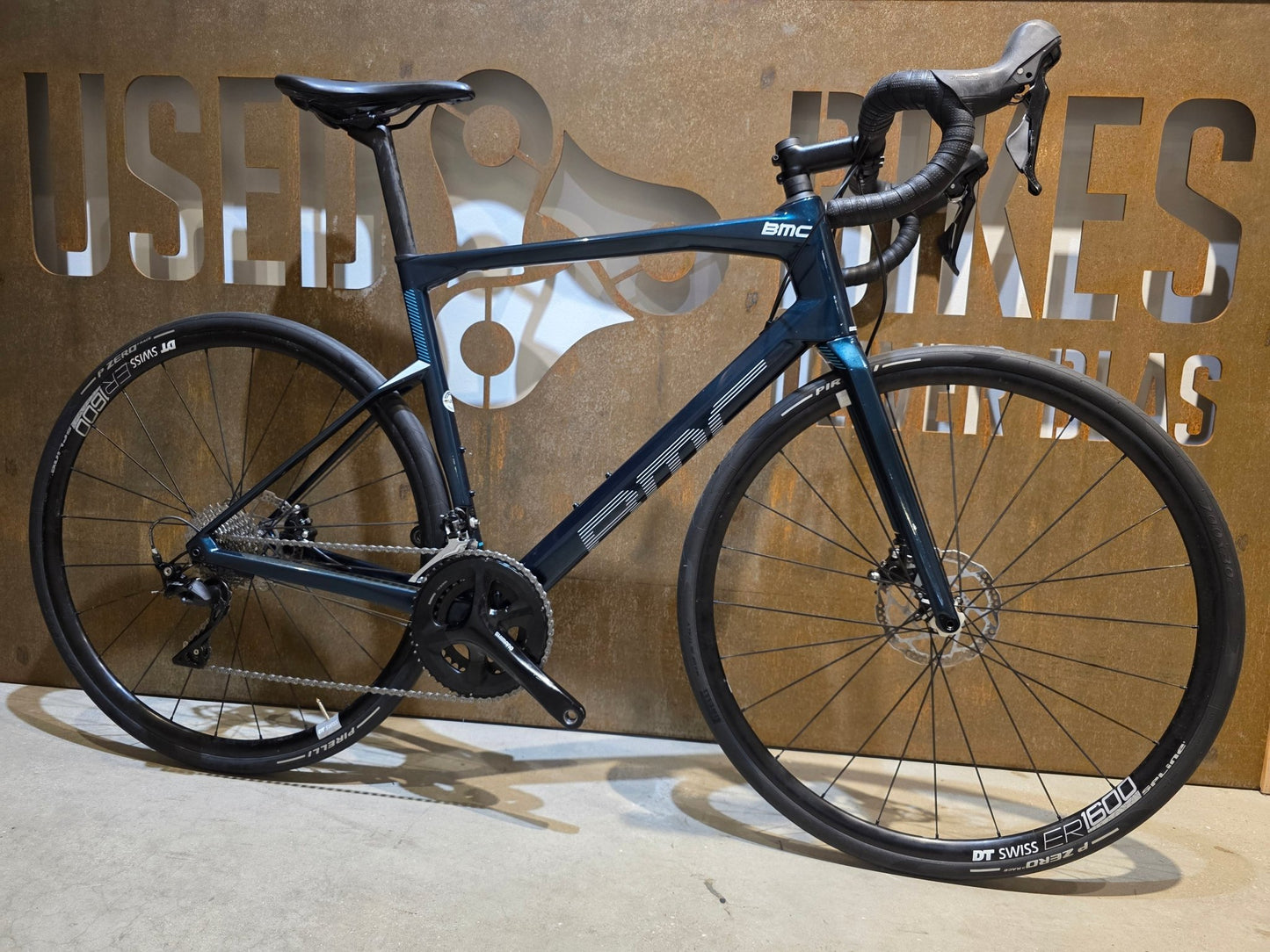 Rennrad von Bmc, BMC ROADMACHINE SEVEN 105 / CUSTOMBUILD / PETROL / 56CM in variant_title vor USEDBIKES - OB.DE Hintergrund