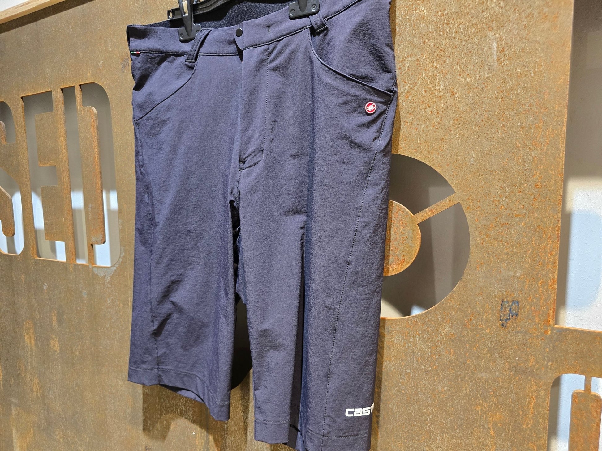 Hosen Herren von Poc, CASTELLI UNLIMITED BAGGY SHORTS / GRAVEL HOSE / HERREN in variant_title vor USEDBIKES - OB.DE Hintergrund