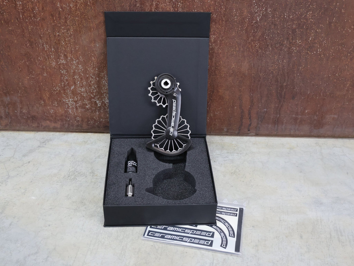 Schaltungsteile von Ceramicspeed, CERAMICSPEED OSPW 3D PRINTED HOLLOW TITANIUM SRAM RED / FORCE AXS vor USEDBIKES - OB.DE Hintergrund