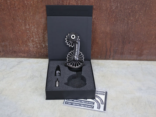 Schaltungsteile von Ceramicspeed, CERAMICSPEED OSPW 3D PRINTED HOLLOW TITANIUM SRAM RED / FORCE AXS vor USEDBIKES - OB.DE Hintergrund