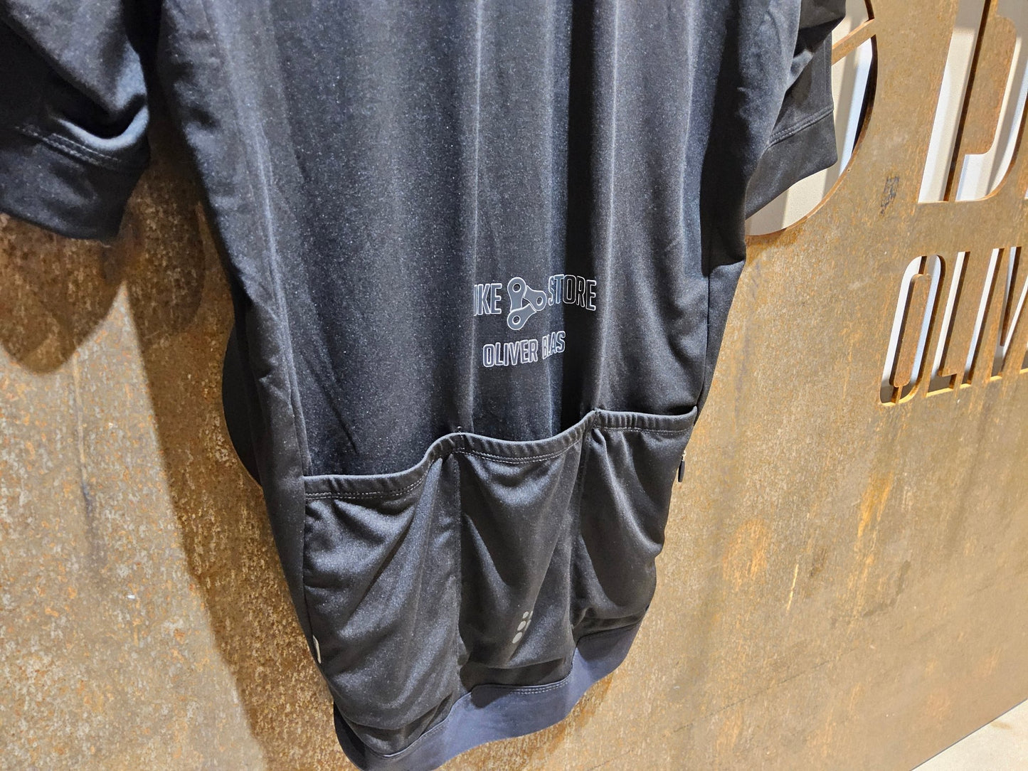 Trikot Herren von Craft, CRAFT ESSENCE BIKESTORE SS JERSEY - HERREN - KURZARM TRIKOT - BLACK in variant_title vor USEDBIKES - OB.DE Hintergrund
