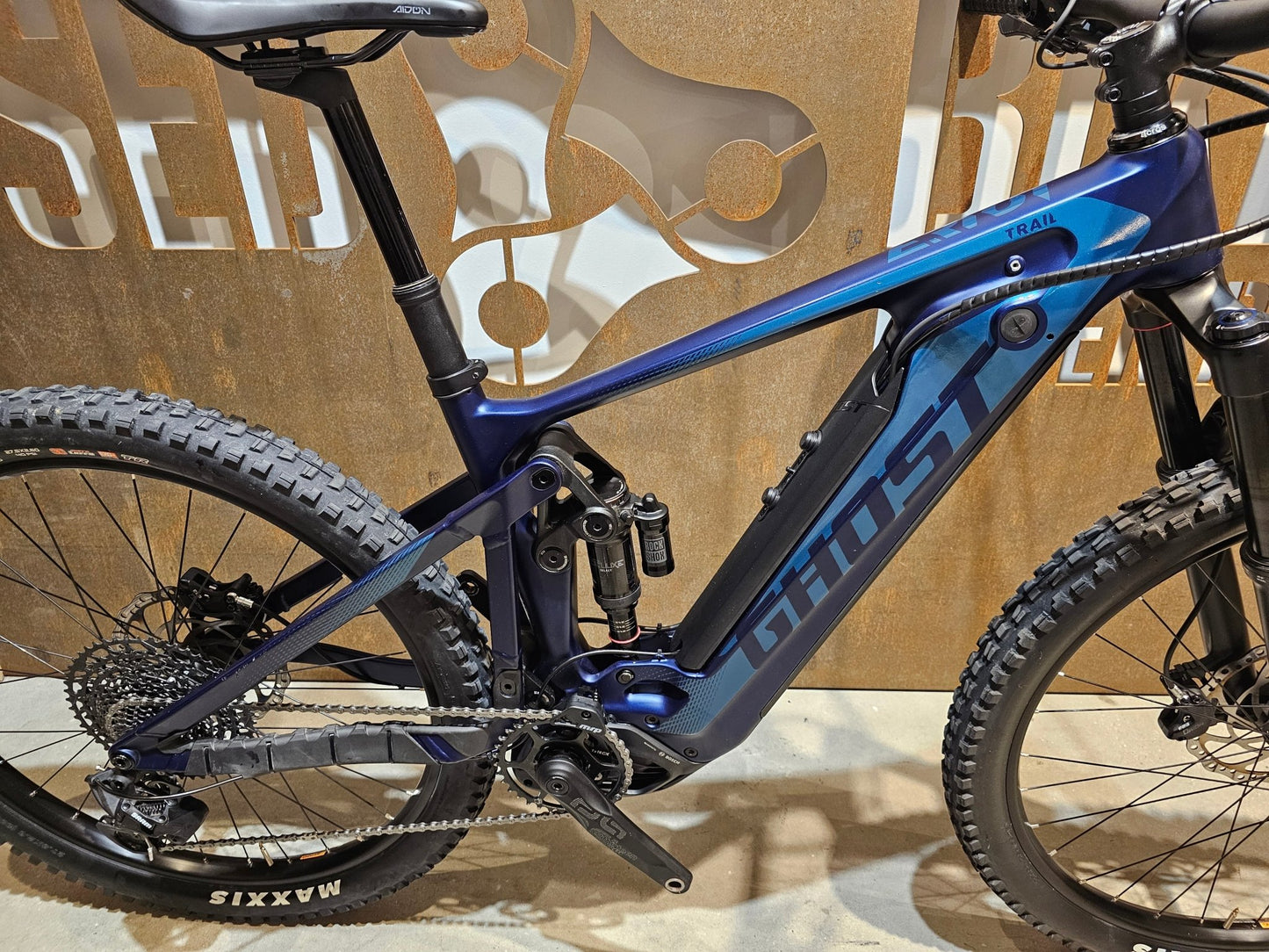 E - Mountainbike von Ghost, GHOST E - RIOT TRAIL CF ADVANCED / S in variant_title vor USEDBIKES - OB.DE Hintergrund