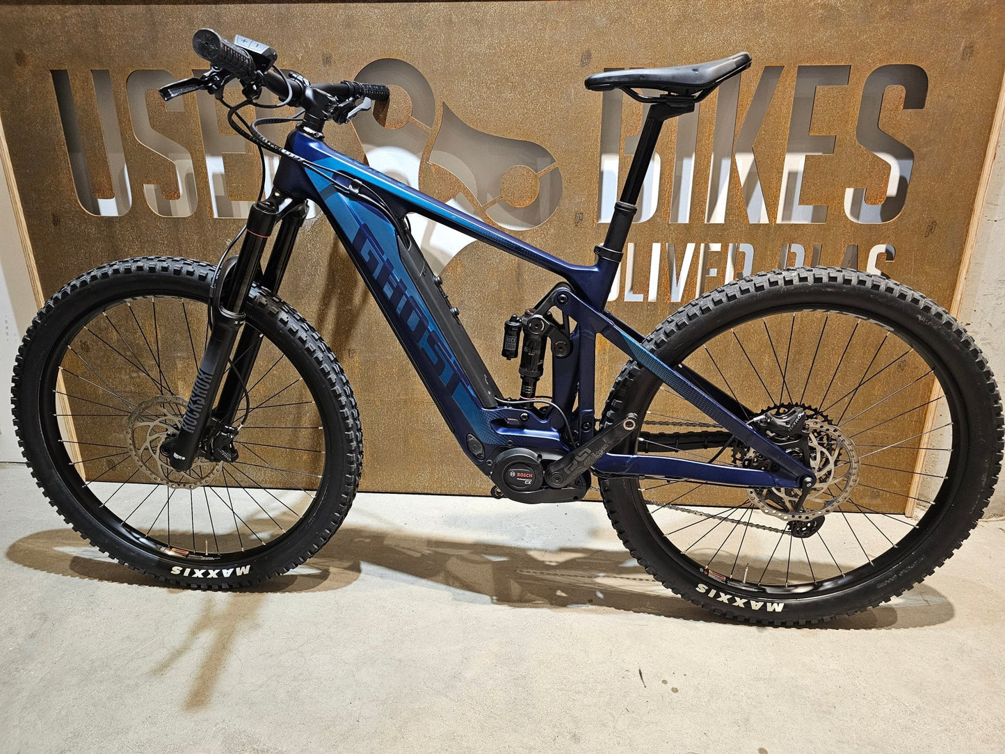E - Mountainbike von Ghost, GHOST E - RIOT TRAIL CF ADVANCED / S in variant_title vor USEDBIKES - OB.DE Hintergrund