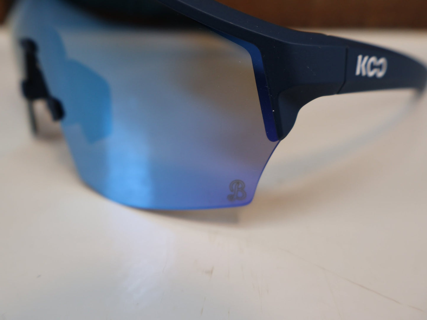 Brillen von Koo, KOO RED BULL - BORA HANSGROHE ALIBI SONNENBRILLE / BLAU MATT vor USEDBIKES - OB.DE Hintergrund