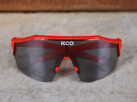 Brillen von Koo, KOO RED BULL - BORA HANSGROHE ALIBI SONNENBRILLE / LEADER EDITION ROT vor USEDBIKES - OB.DE Hintergrund