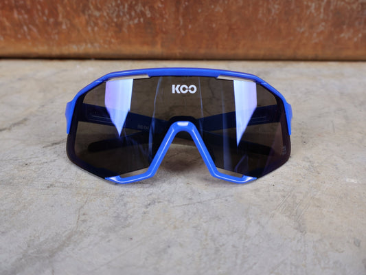 Brillen von Koo, KOO RED BULL - BORA HANSGROHE DEMOS SONNENBRILLE / LEADER EDITION BLAU vor USEDBIKES - OB.DE Hintergrund