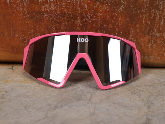 Brillen von Koo, KOO RED BULL - BORA HANSGROHE SPECTRO SONNENBRILLE / CHAMPION LEADER ROSA vor USEDBIKES - OB.DE Hintergrund