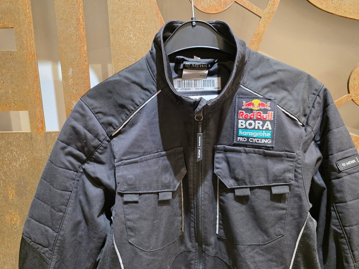 Freizeitbekleidung - BOH von Mewa, MEWA RED BULL - BORA HANSGROHE PEAK ARBEITSJACKE STAFF / HERREN in variant_title vor USEDBIKES - OB.DE Hintergrund