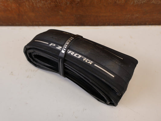 Reifen von Pirelli, PIRELLI P ZERO RACE TLR RENNRADREIFEN SCHWARZ 700x26c / ETRTO 26-622 vor USEDBIKES-OB.DE Hintergrund