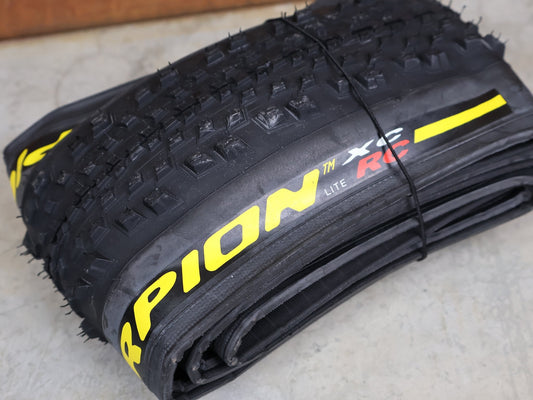 Reifen von Pirelli, PIRELLI SCORPION XC RC LITE 29×2.4 – TUBELESS READY MTB REIFEN YELLOW vor USEDBIKES - OB.DE Hintergrund
