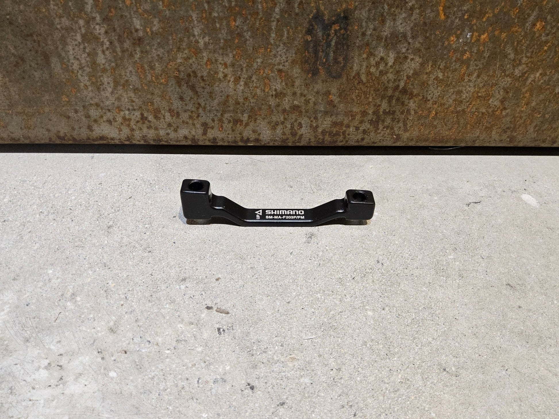 Zubehör von Shimano, SHIMANO ADAPTER POSTMOUNT 203MM / VORNE O. HINTEN vor USEDBIKES - OB.DE Hintergrund