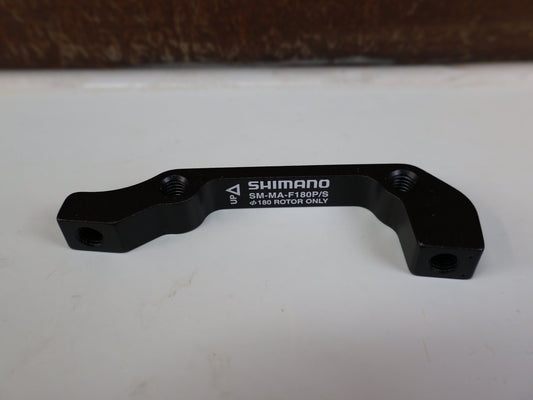 Zubehör von Shimano, SHIMANO ADAPTER SM-MA-F180P/SA / IS 2000 GABEL AUF PM BREMSSATTEL / VR 180 MM vor USEDBIKES-OB.DE Hintergrund
