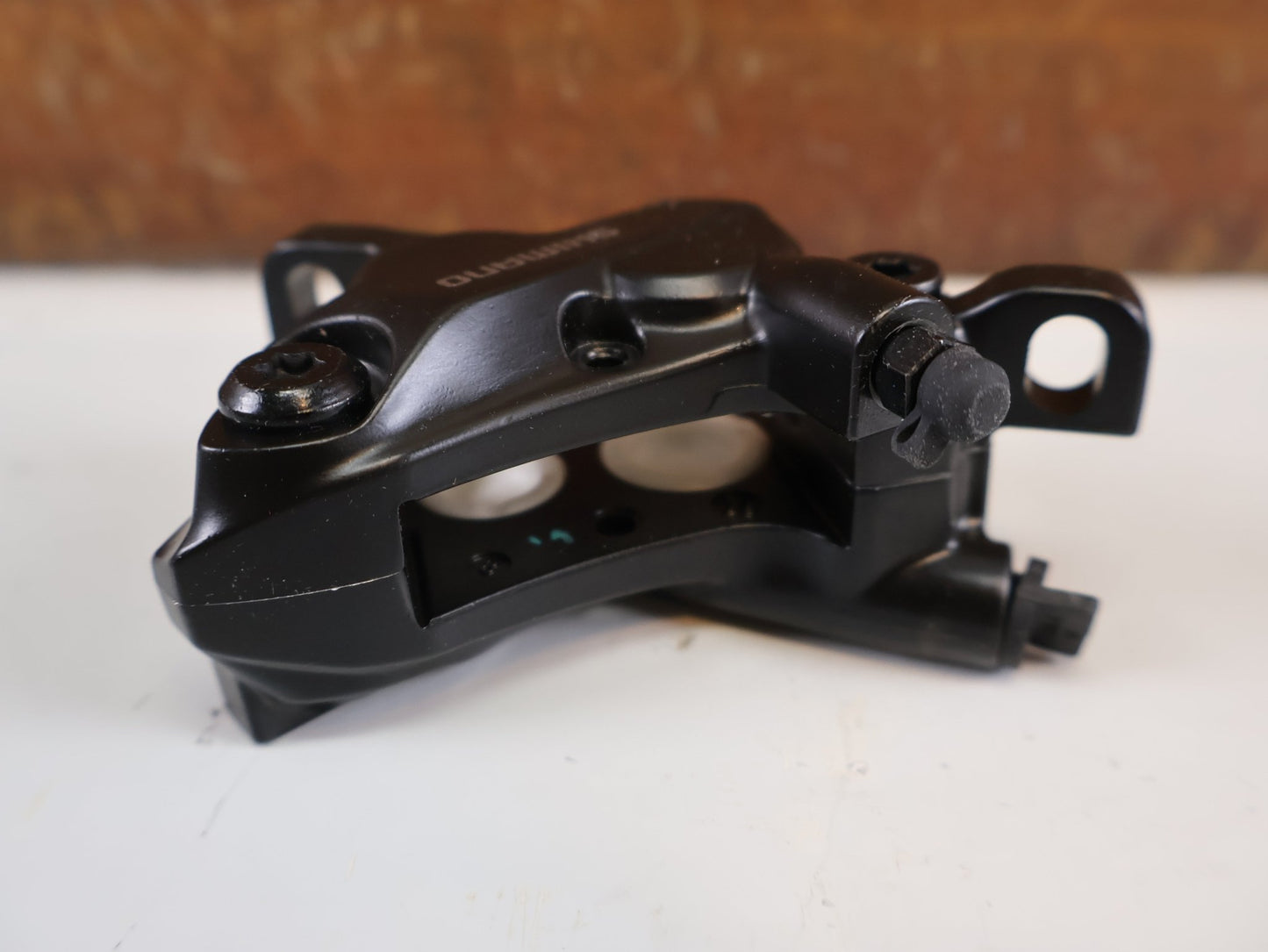 Bremse von Shimano, SHIMANO BR - MT520 BREMSSATTEL / 4 - KOLBEN / POSTMOUNT / KERAMIK - KOLBEN / EBRMT520MPRXL vor USEDBIKES - OB.DE Hintergrund
