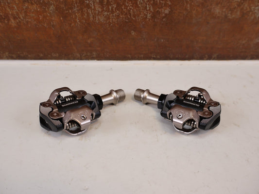 Pedale von Shimano, Shimano Deore XT PD-M8100 SPD Pedale Klickpedale 342g vor USEDBIKES-OB.DE Hintergrund