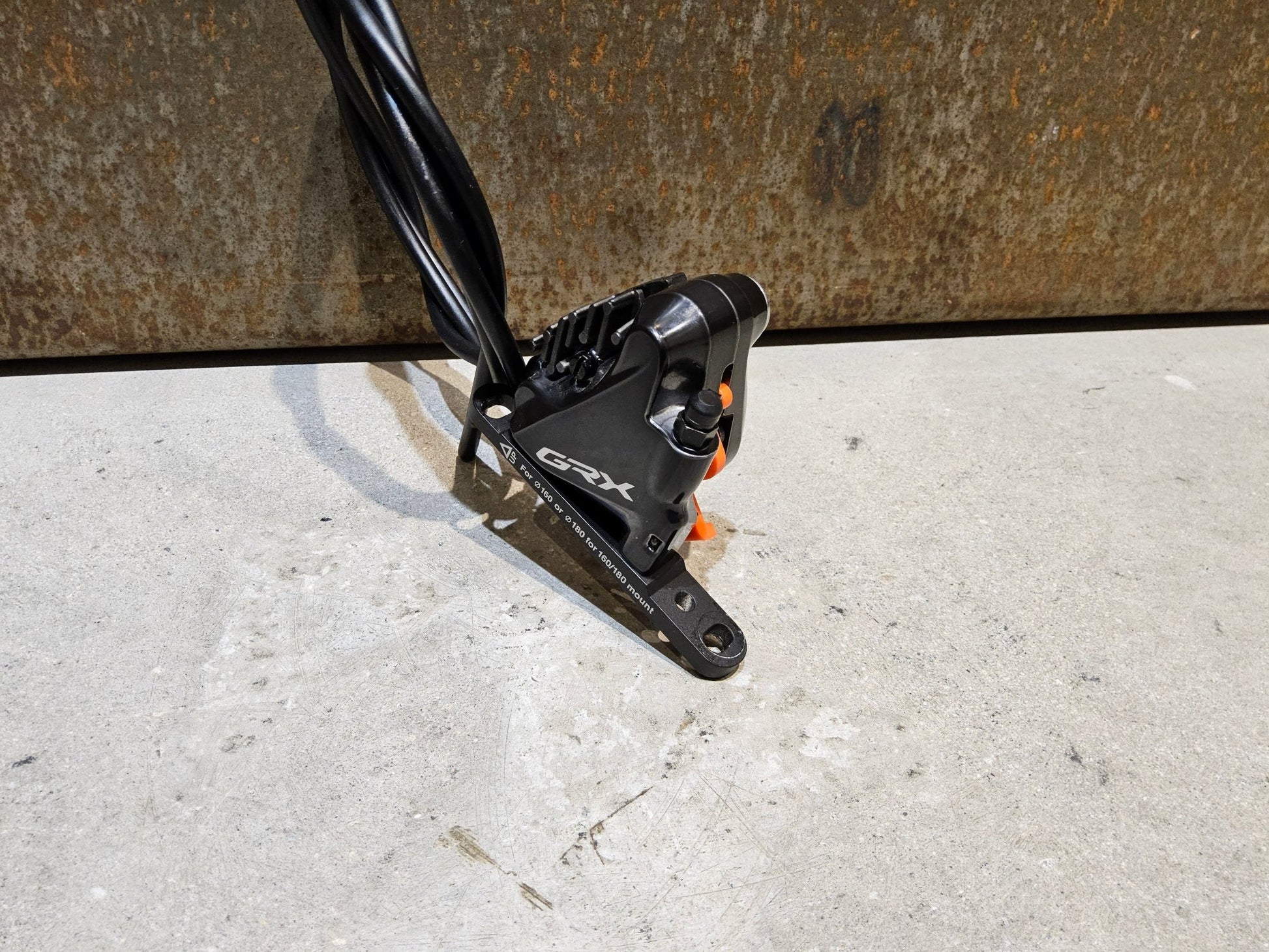 Bremse von Shimano, SHIMANO GRX BREMSSATTEL BR - RX810 - F / - R FLATMOUNT VORNE / HINTEN INKL. LEITUNG in variant_title vor USEDBIKES - OB.DE Hintergrund