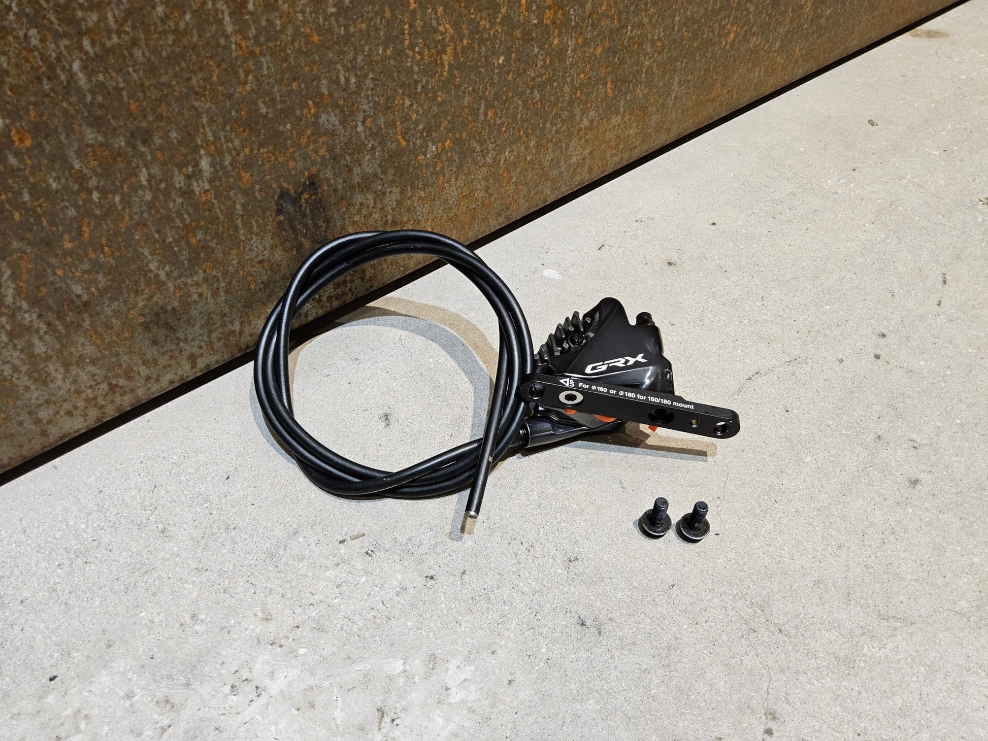 Bremse von Shimano, SHIMANO GRX BREMSSATTEL BR - RX810 - F / - R FLATMOUNT VORNE / HINTEN INKL. LEITUNG in variant_title vor USEDBIKES - OB.DE Hintergrund