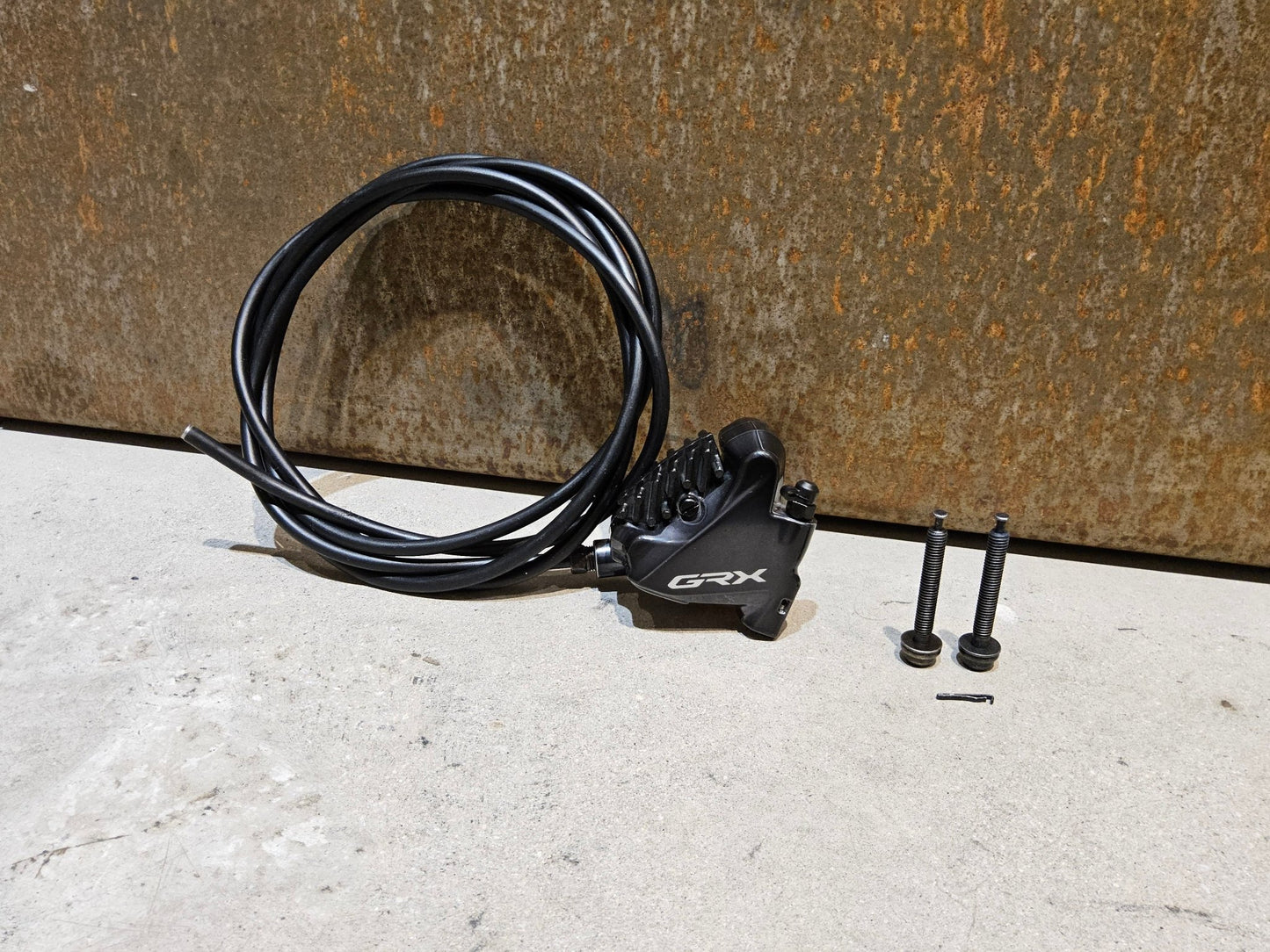 Bremse von Shimano, SHIMANO GRX BREMSSATTEL BR - RX810 - F / - R FLATMOUNT VORNE / HINTEN INKL. LEITUNG in variant_title vor USEDBIKES - OB.DE Hintergrund