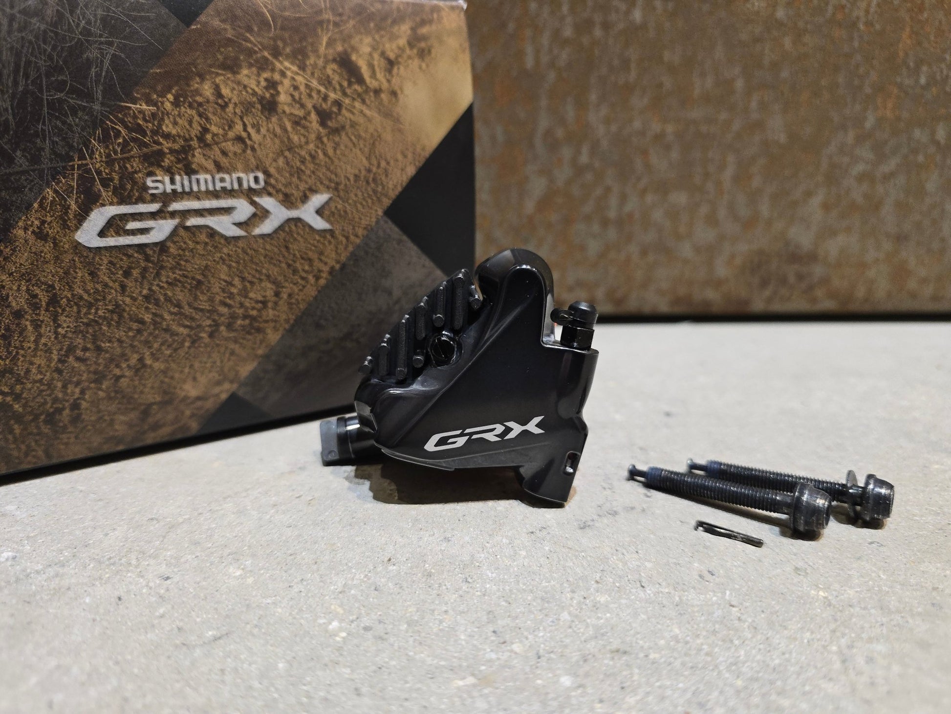 Bremse von Shimano, SHIMANO GRX BREMSSATTEL BR - RX810 - F / - R FLATMOUNT VORNE / HINTEN in variant_title vor USEDBIKES - OB.DE Hintergrund