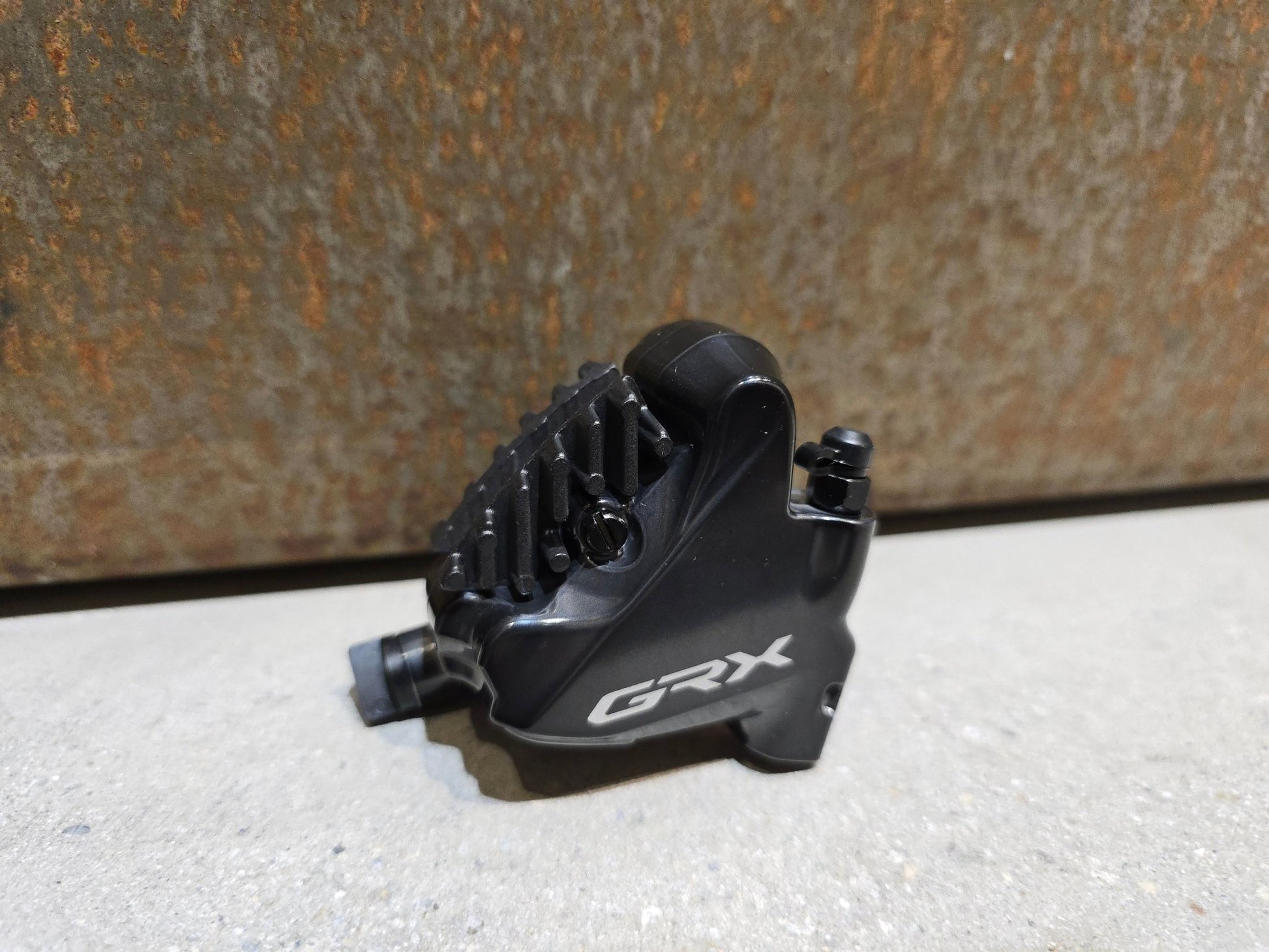 Bremse von Shimano, SHIMANO GRX BREMSSATTEL BR - RX810 - F / - R FLATMOUNT VORNE / HINTEN in variant_title vor USEDBIKES - OB.DE Hintergrund