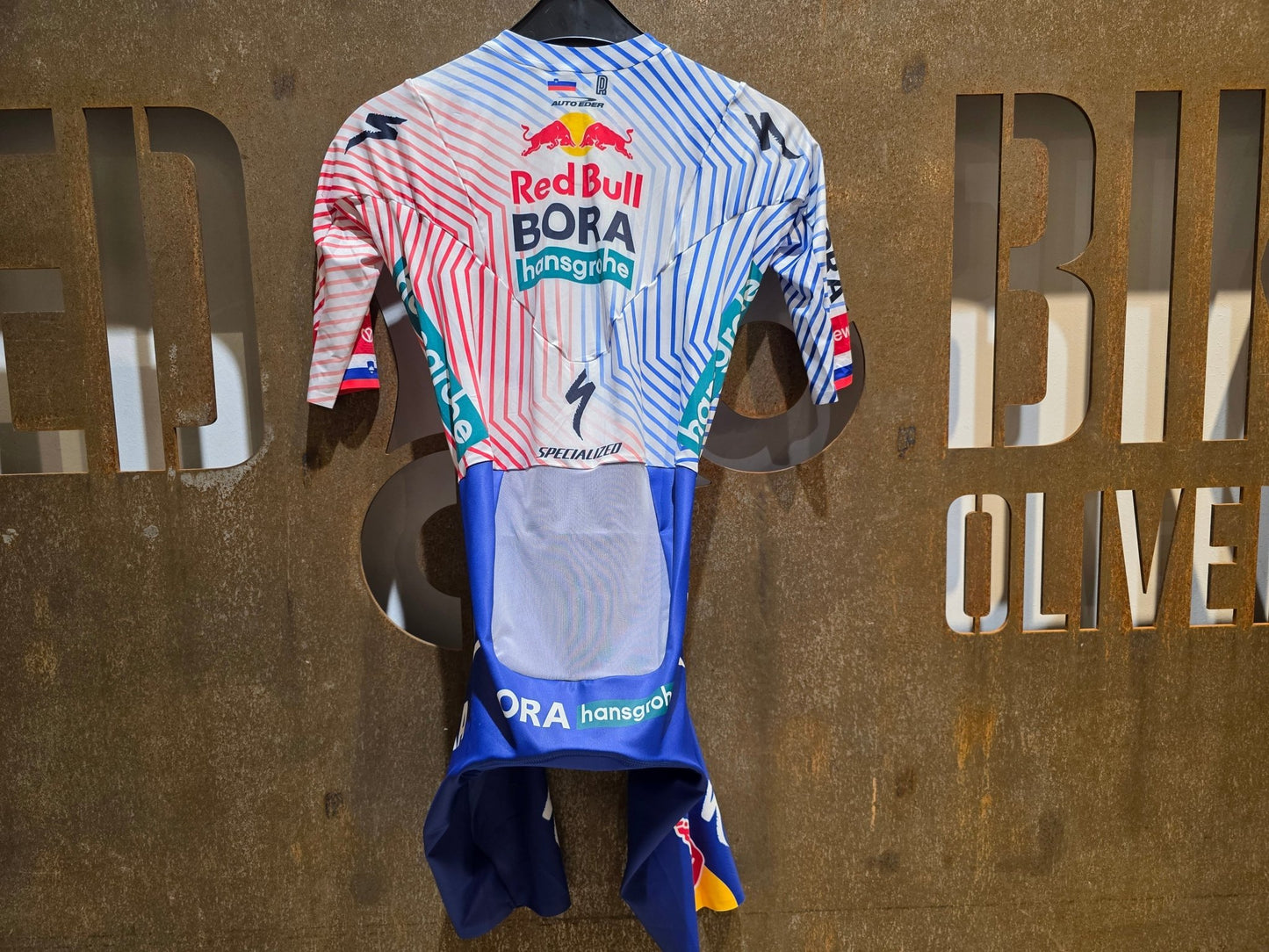 Anzug - BOH von Specialized, SPECIALIZED RED BULL - BORA HANSGROHE AERO SKIN SUIT SS / EINTEILER ROGLIC vor USEDBIKES - OB.DE Hintergrund