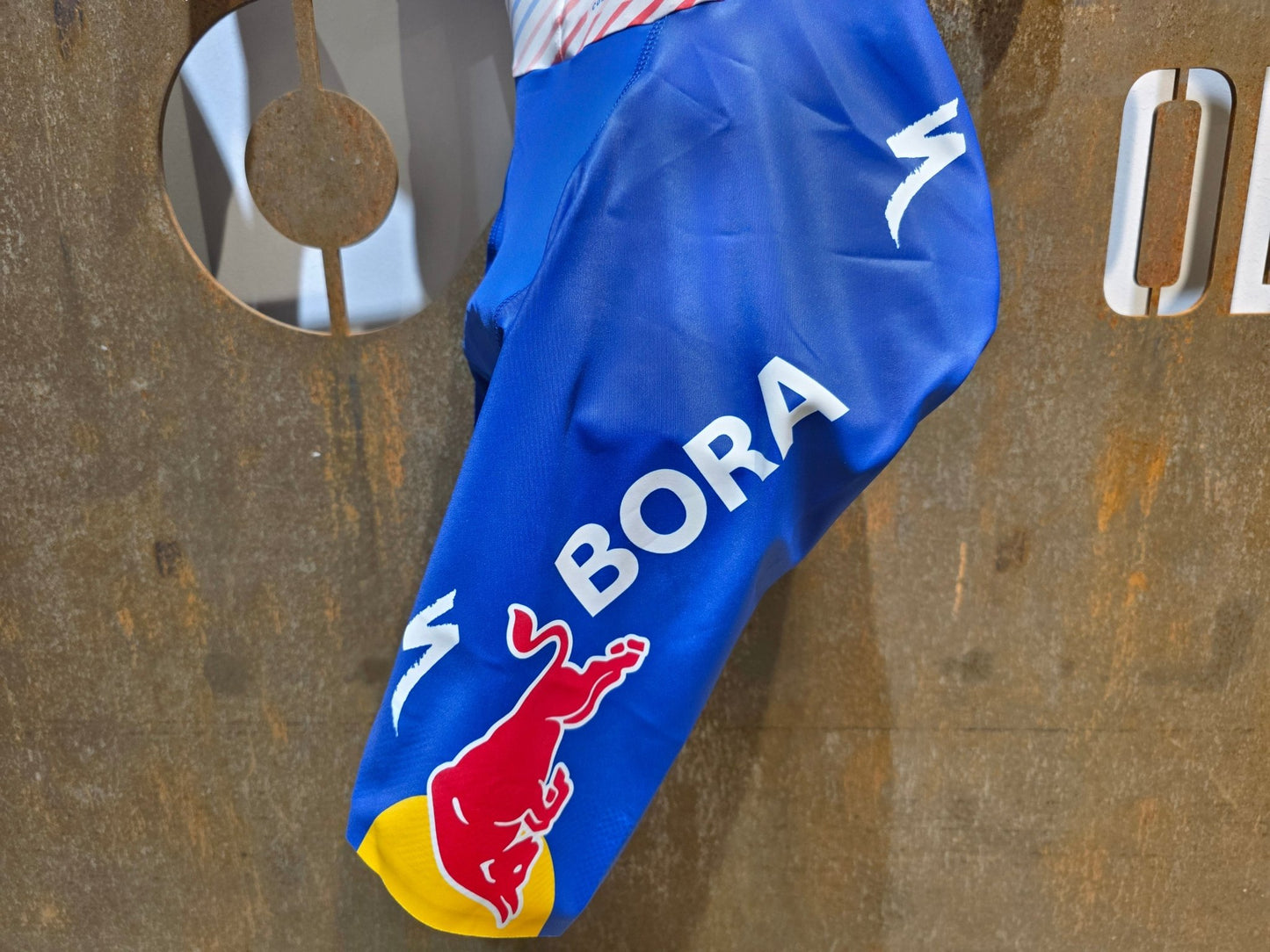 Anzug - BOH von Specialized, SPECIALIZED RED BULL - BORA HANSGROHE AERO SKIN SUIT SS / EINTEILER vor USEDBIKES - OB.DE Hintergrund