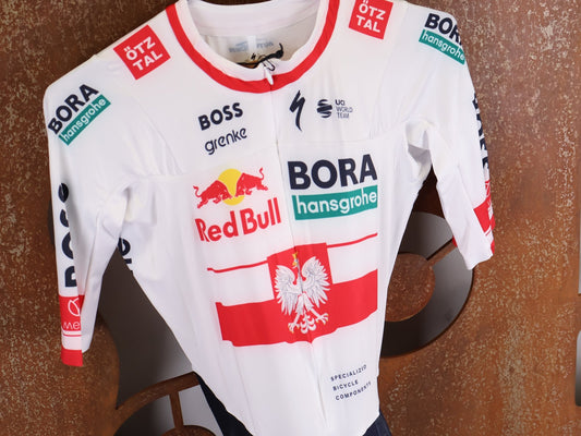 Anzug - BOH von Specialized, SPECIALIZED RED BULL - BORA HANSGROHE AERO SKIN SUIT SS / POLAND CHAMPION vor USEDBIKES - OB.DE Hintergrund