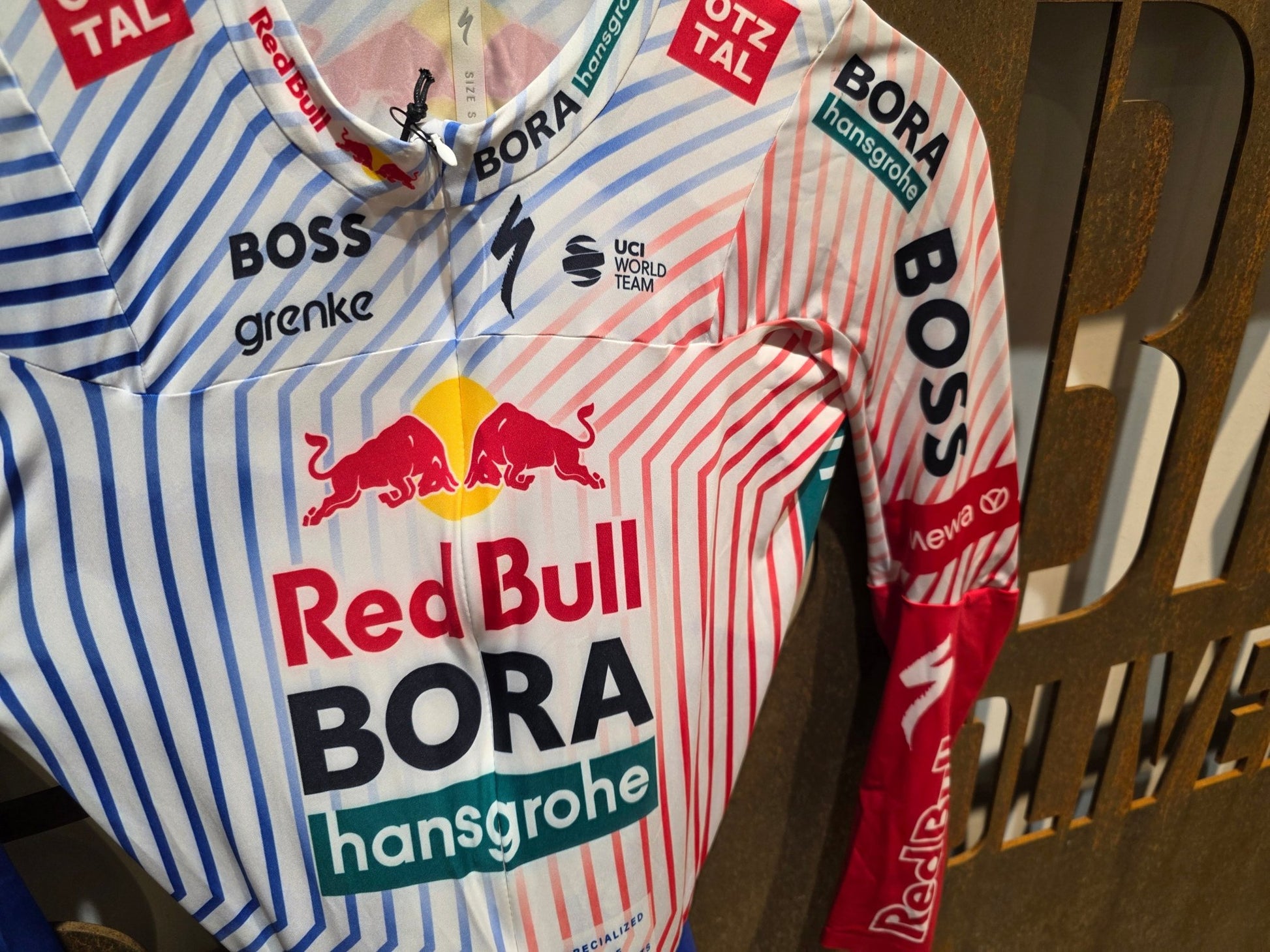 Anzug - BOH von Specialized, SPECIALIZED RED BULL - BORA HANSGROHE AERO SKIN SUIT TDF / LANGARM EINTEILER vor USEDBIKES - OB.DE Hintergrund