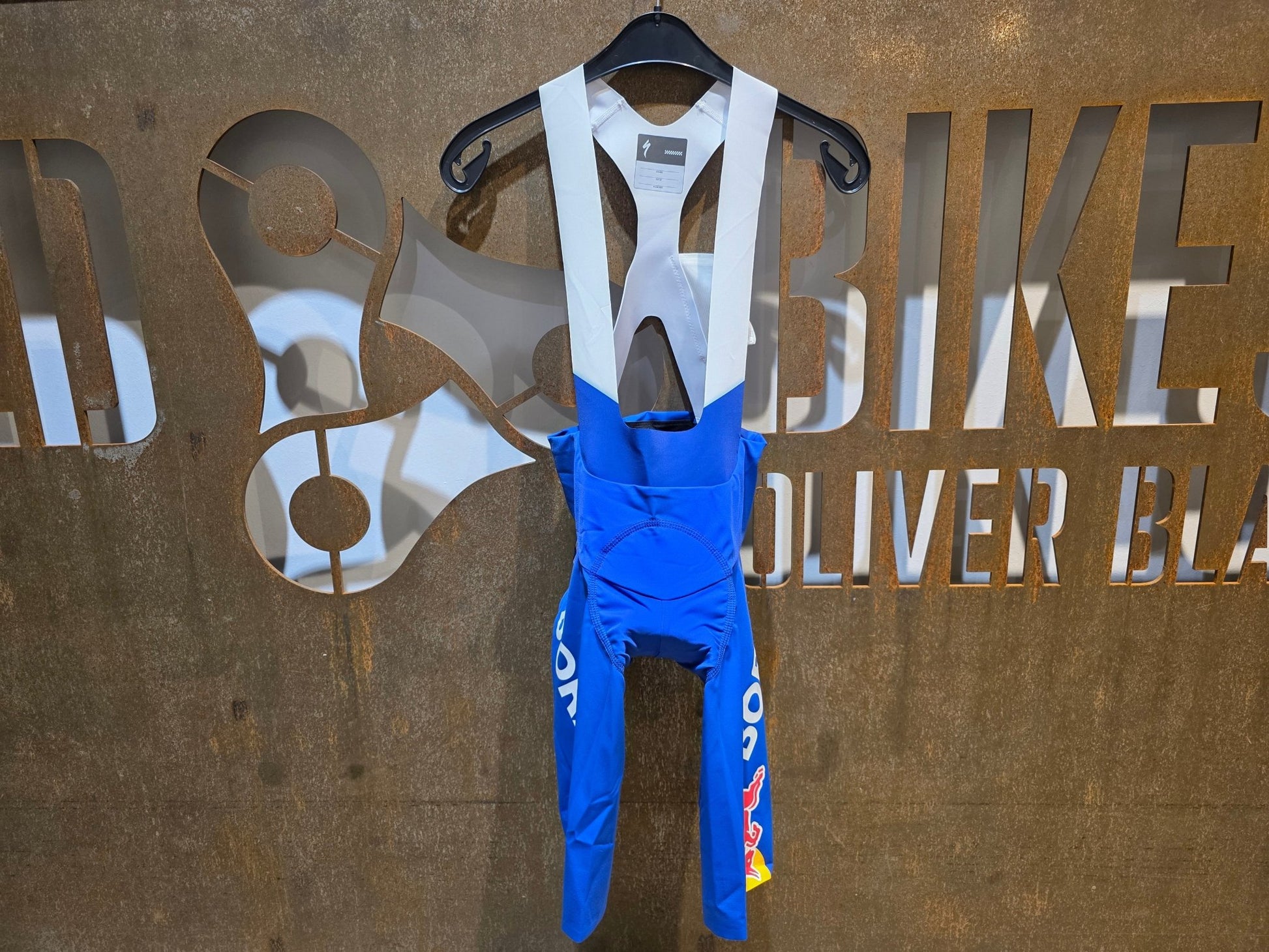 Hosen - BOH von Specialized, SPECIALIZED RED BULL - BORA HANSGROHE BIB SHORT LTD TDF / KURZE TRÄGERHOSE vor USEDBIKES - OB.DE Hintergrund