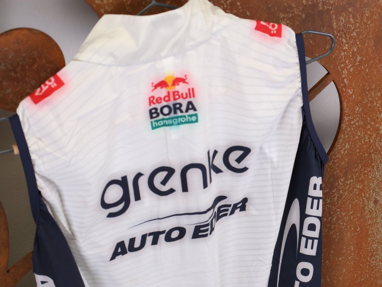 Westen - BOH von Specialized, SPECIALIZED TGA ROOKIES OF RED BULL - BORA HANSGROHE WIND VEST / WESTE vor USEDBIKES - OB.DE Hintergrund