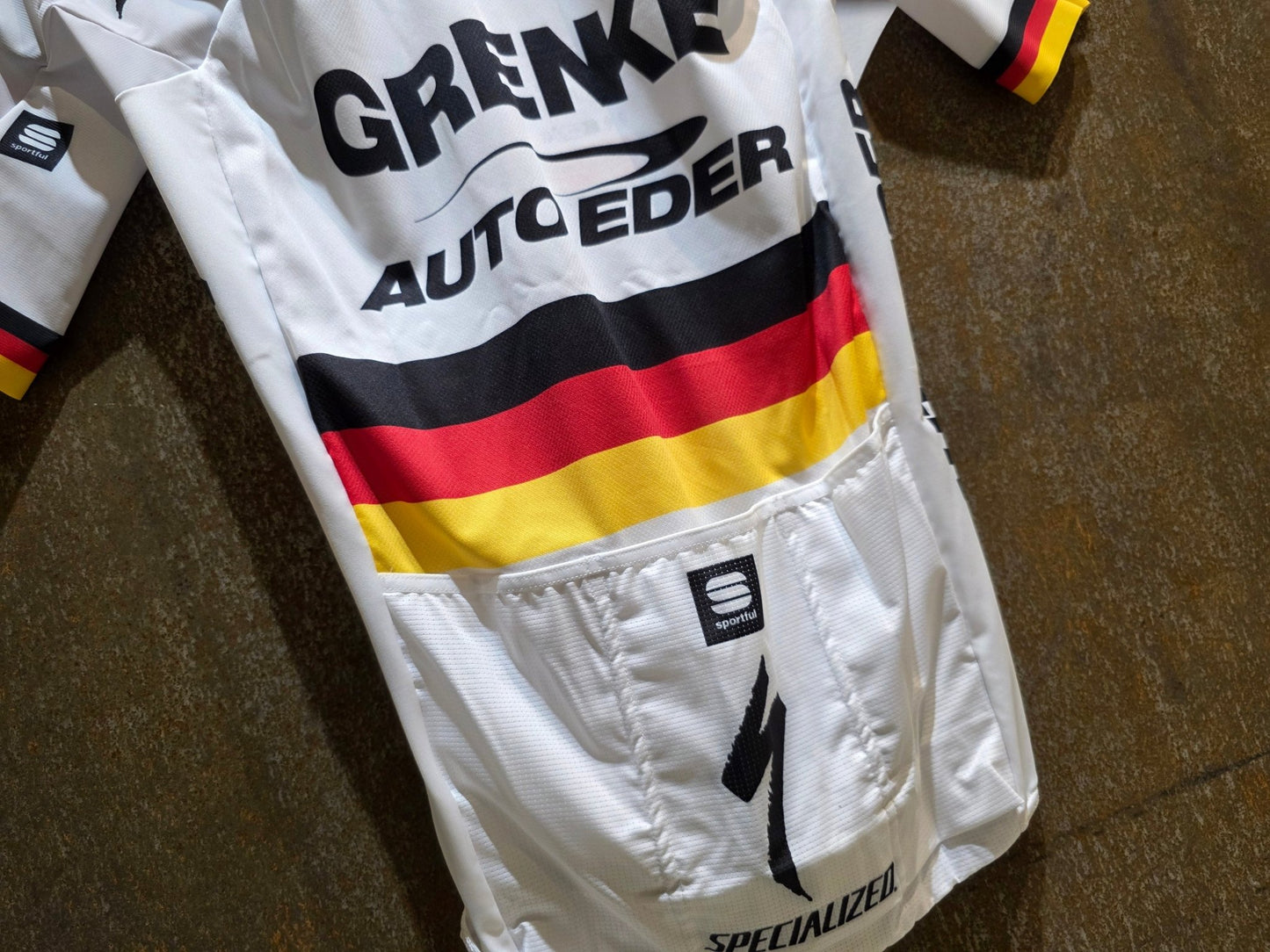 Kurzarm Trikot - U19 von Sportful, SPORTFUL GRENKE - AUTO EDER BOMBER JERSEY / KURZARM TRIKOT / DEUTSCHER MEISTER in variant_title vor USEDBIKES - OB.DE Hintergrund