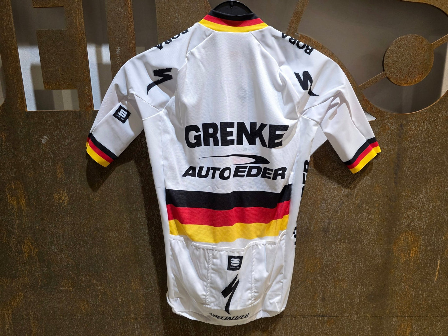 Kurzarm Trikot - U19 von Sportful, SPORTFUL GRENKE - AUTO EDER BOMBER JERSEY / KURZARM TRIKOT / DEUTSCHER MEISTER in variant_title vor USEDBIKES - OB.DE Hintergrund