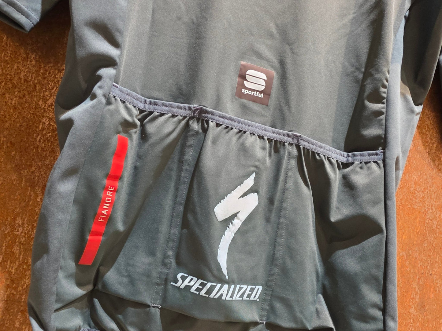 Kurzarm Trikot - U19 von Sportful, SPORTFUL GRENKE - AUTO EDER FIANDRE SS JACKET / KURZARM JACKE in variant_title vor USEDBIKES - OB.DE Hintergrund