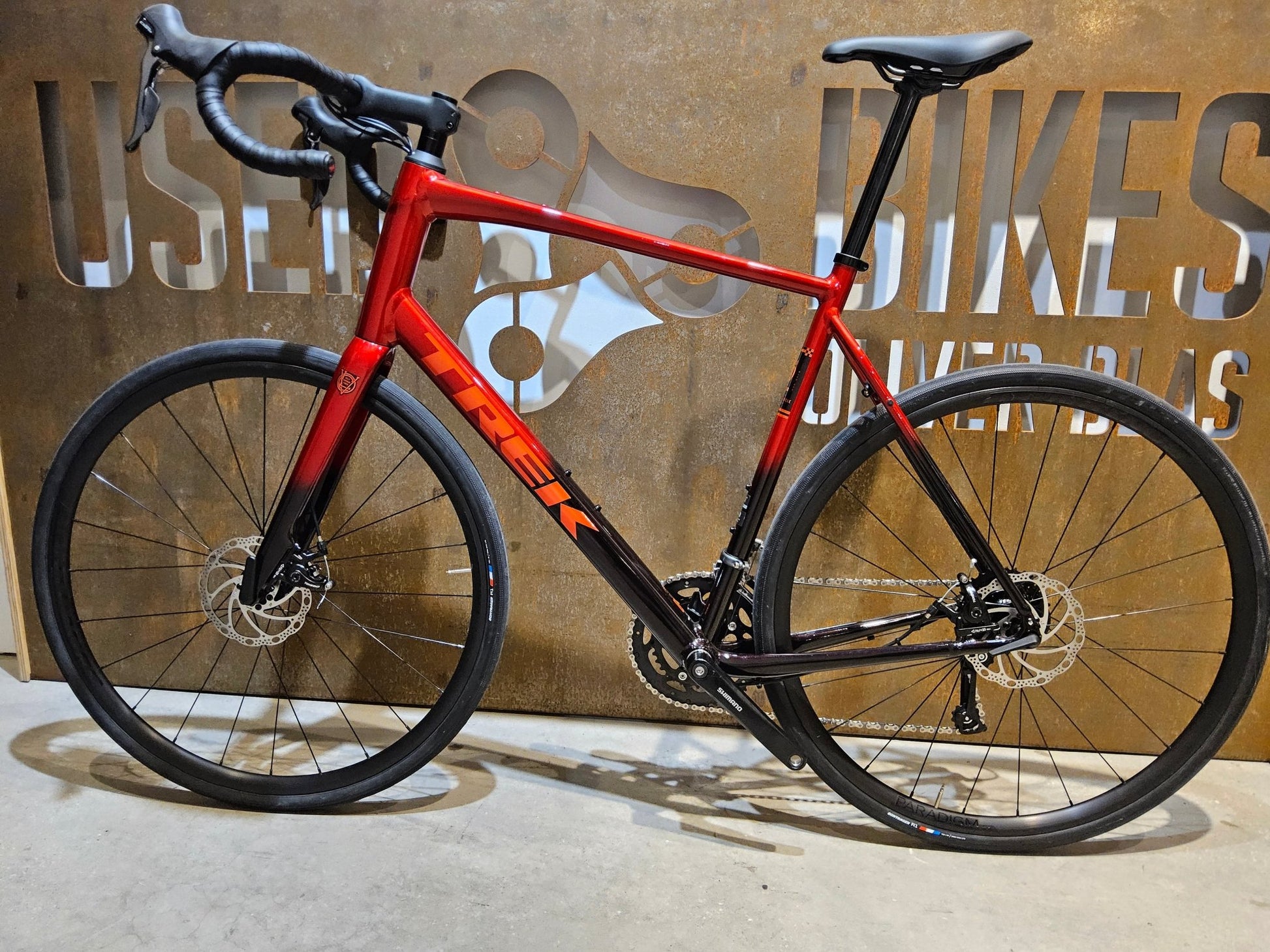 Rennrad von Trek, TREK DOMANE AL 2 GEN 4 / CRIMSON / 61CM in variant_title vor USEDBIKES - OB.DE Hintergrund