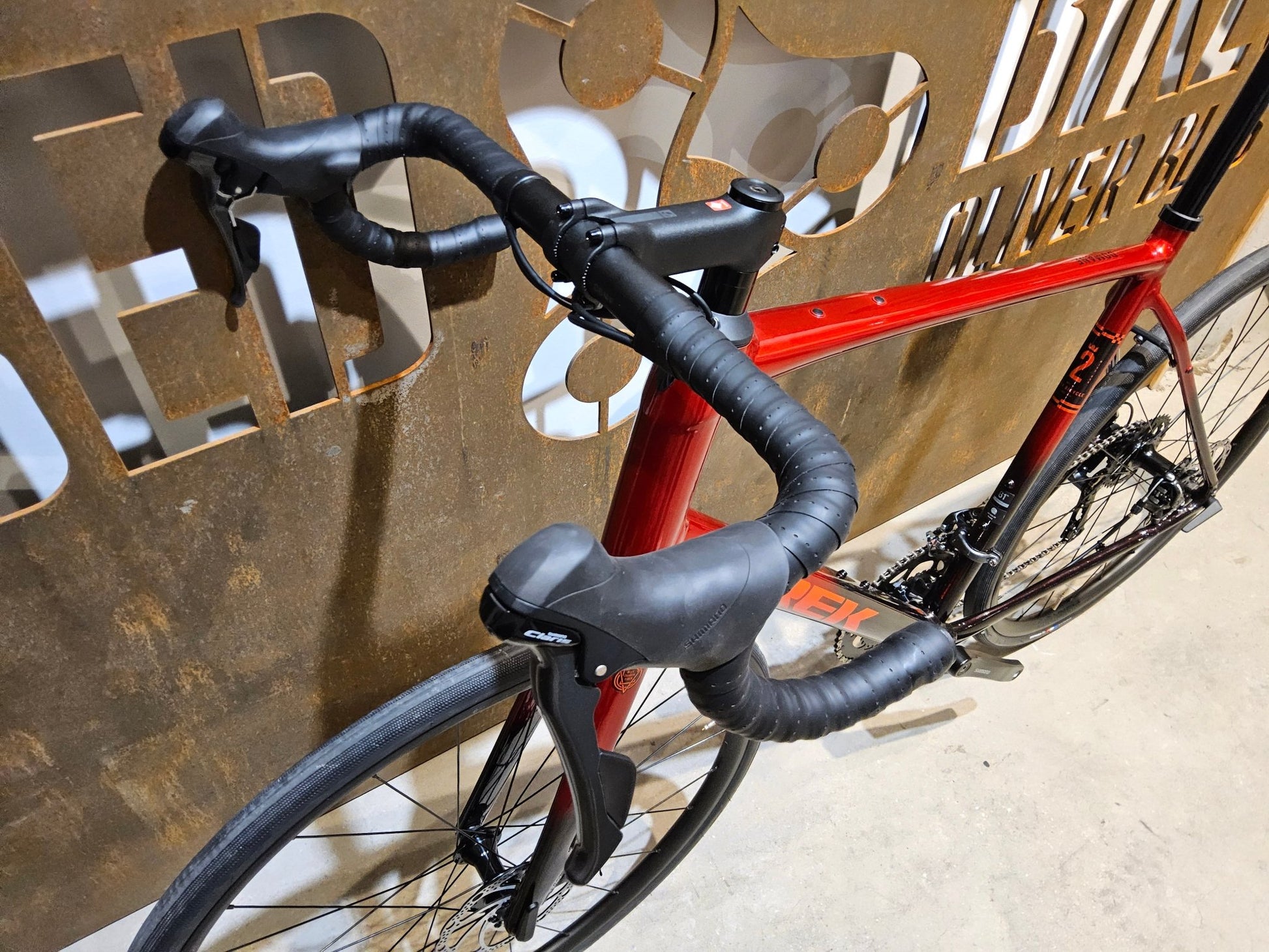 Rennrad von Trek, TREK DOMANE AL 2 GEN 4 / CRIMSON / 61CM in variant_title vor USEDBIKES - OB.DE Hintergrund