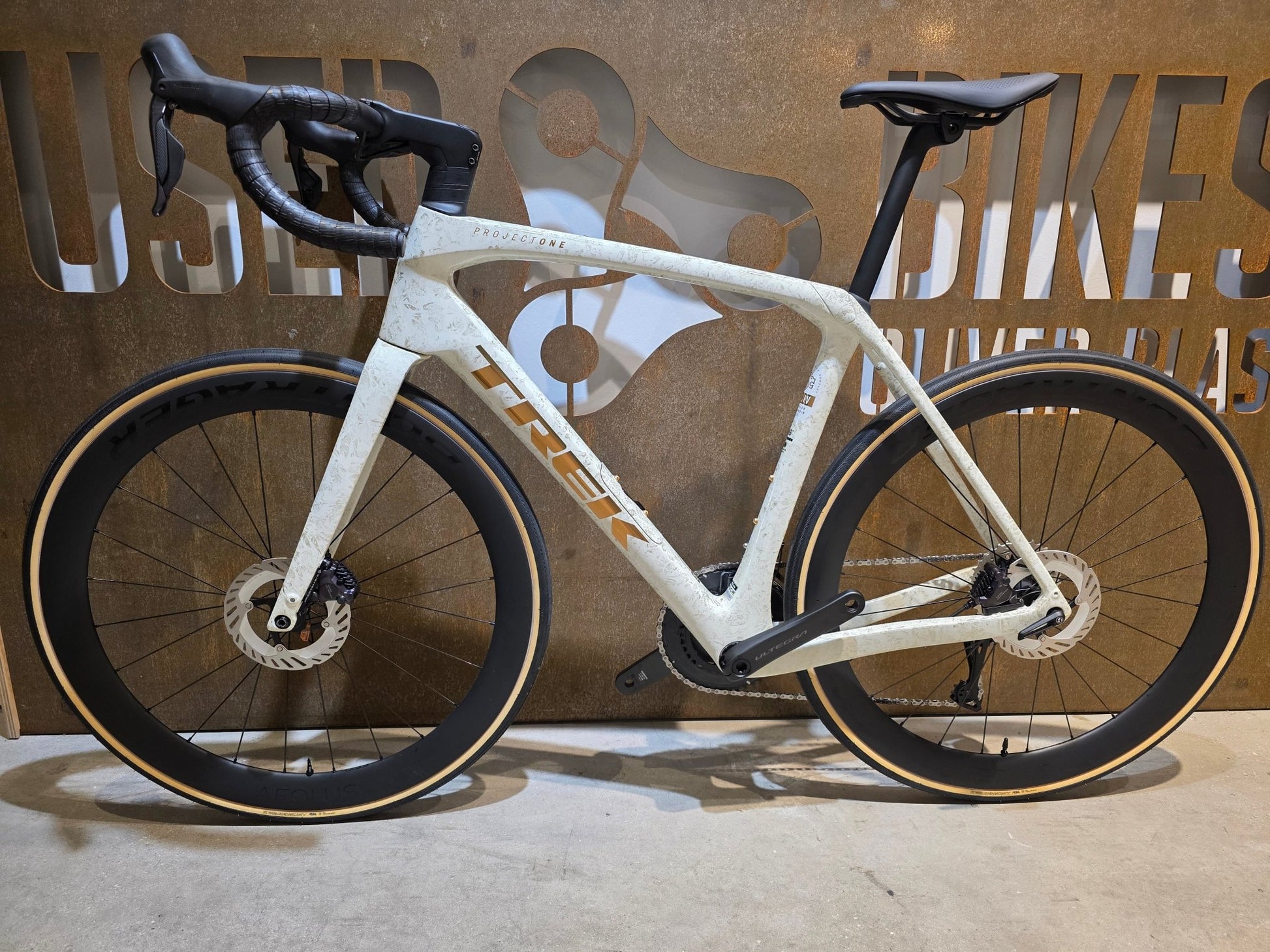 Rennrad von Trek, TREK DOMANE SLR 7 GEN 4 / ERA WHITE / SUPERNOVA MARBLE / 56CM vor USEDBIKES - OB.DE Hintergrund