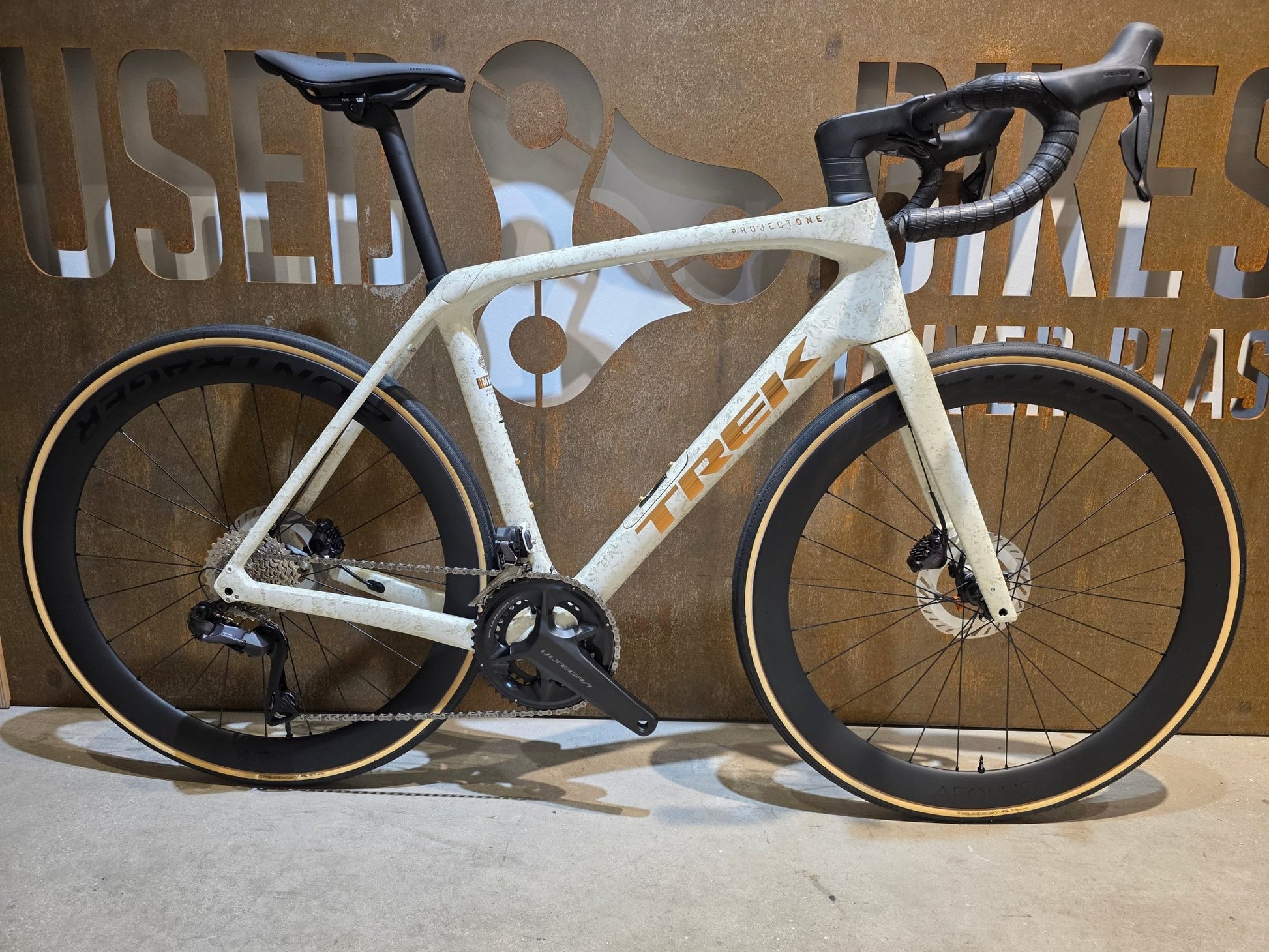 Rennrad von Trek, TREK DOMANE SLR 7 GEN 4 / ERA WHITE / SUPERNOVA MARBLE / 56CM vor USEDBIKES - OB.DE Hintergrund