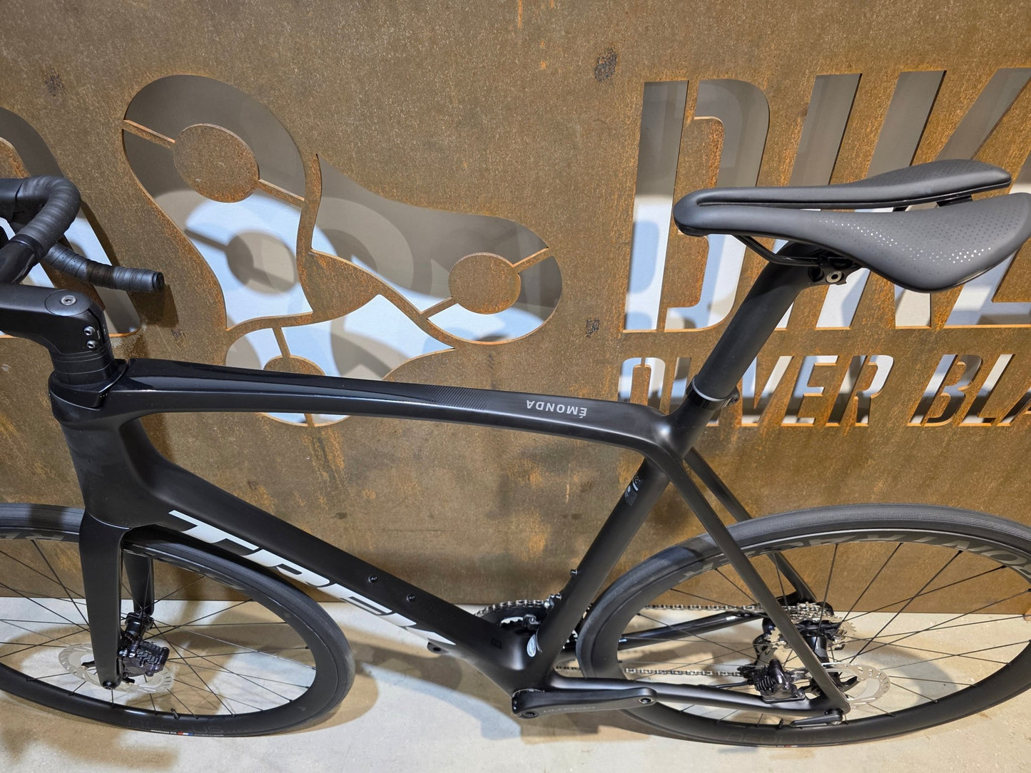 Rennrad von Trek, TREK EMONDA SL 7 / MATTE CARBON SMOKE / 62CM in variant_title vor USEDBIKES - OB.DE Hintergrund