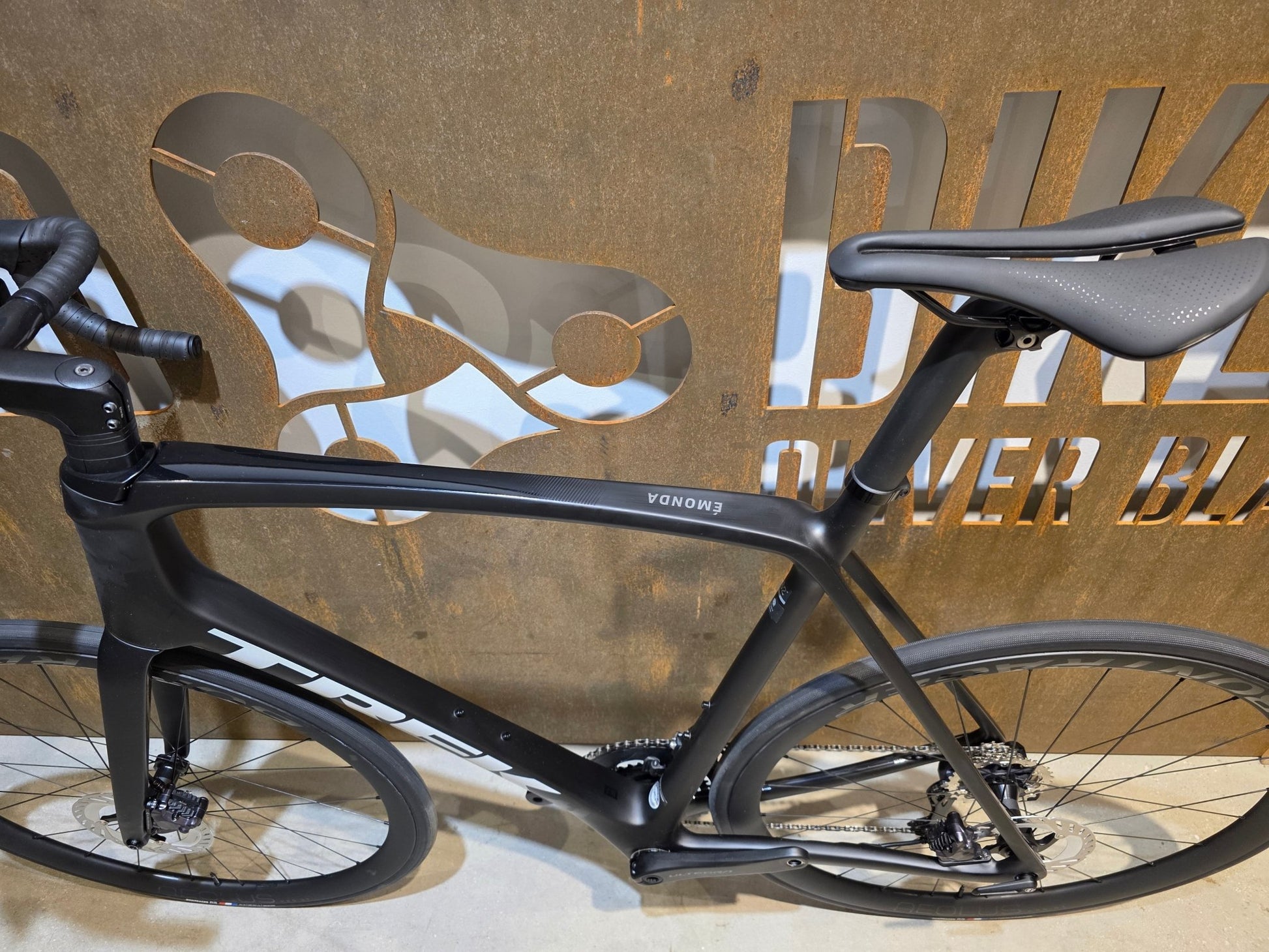 Rennrad von Trek, TREK EMONDA SL 7 / MATTE CARBON SMOKE / 62CM in variant_title vor USEDBIKES - OB.DE Hintergrund