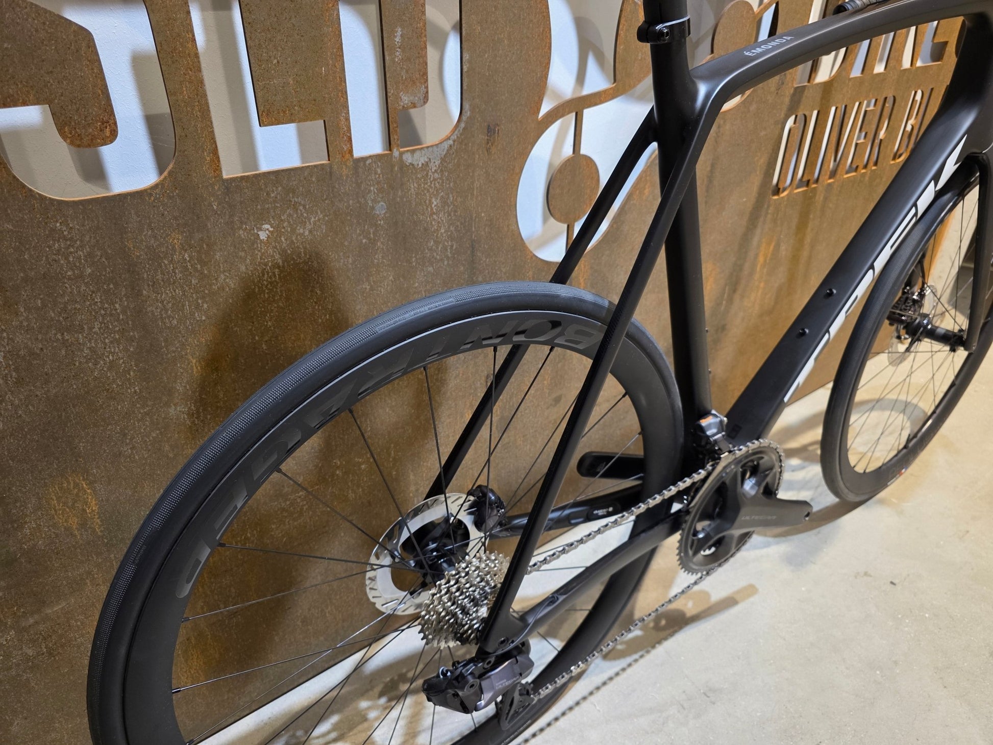 Rennrad von Trek, TREK EMONDA SL 7 / MATTE CARBON SMOKE / 62CM in variant_title vor USEDBIKES - OB.DE Hintergrund