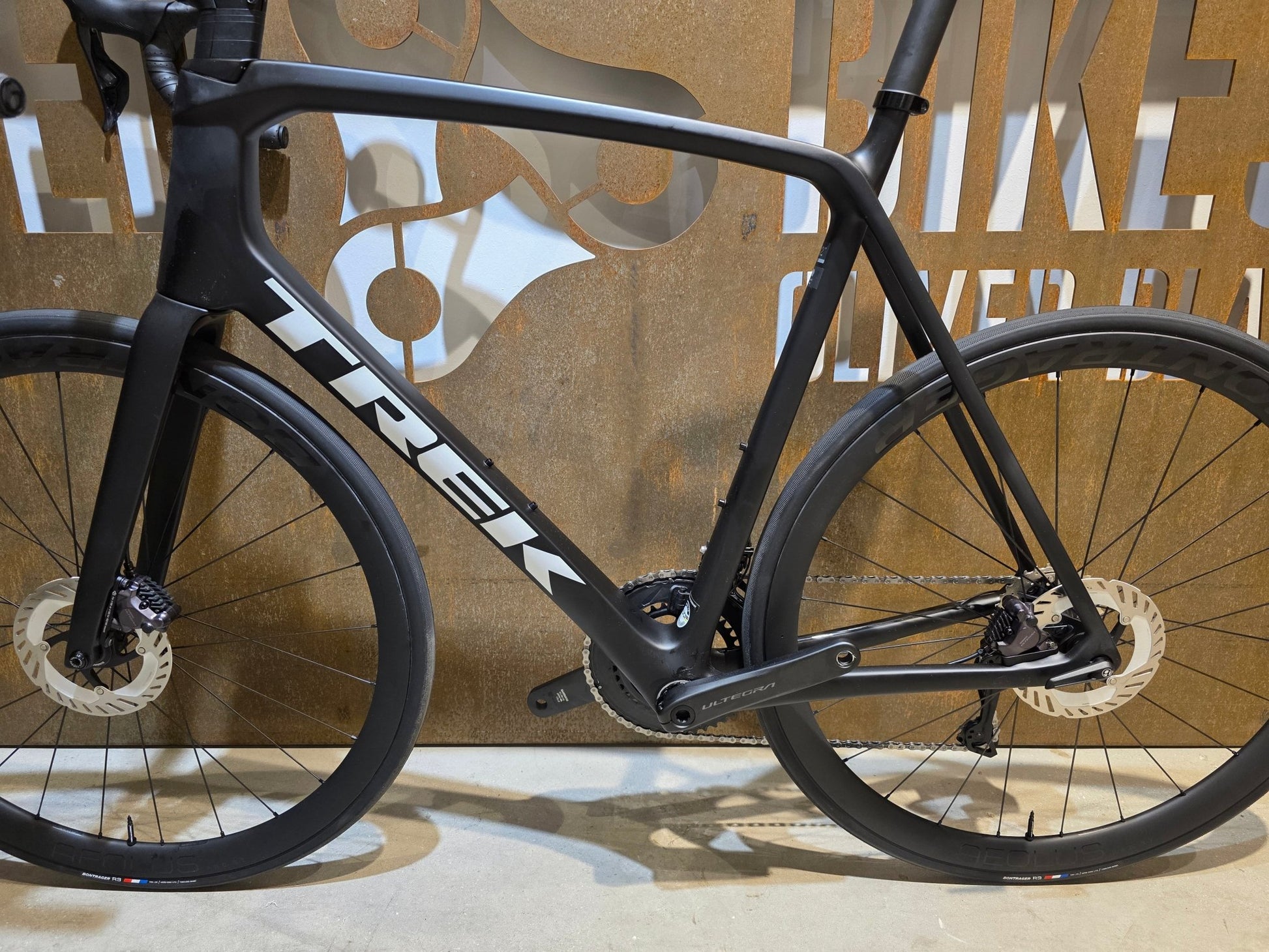 Rennrad von Trek, TREK EMONDA SL 7 / MATTE CARBON SMOKE / 62CM in variant_title vor USEDBIKES - OB.DE Hintergrund