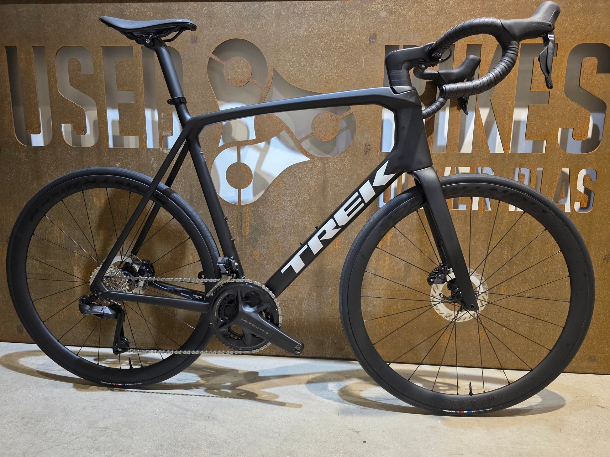 Rennrad von Trek, TREK EMONDA SL 7 / MATTE CARBON SMOKE / 62CM in variant_title vor USEDBIKES - OB.DE Hintergrund