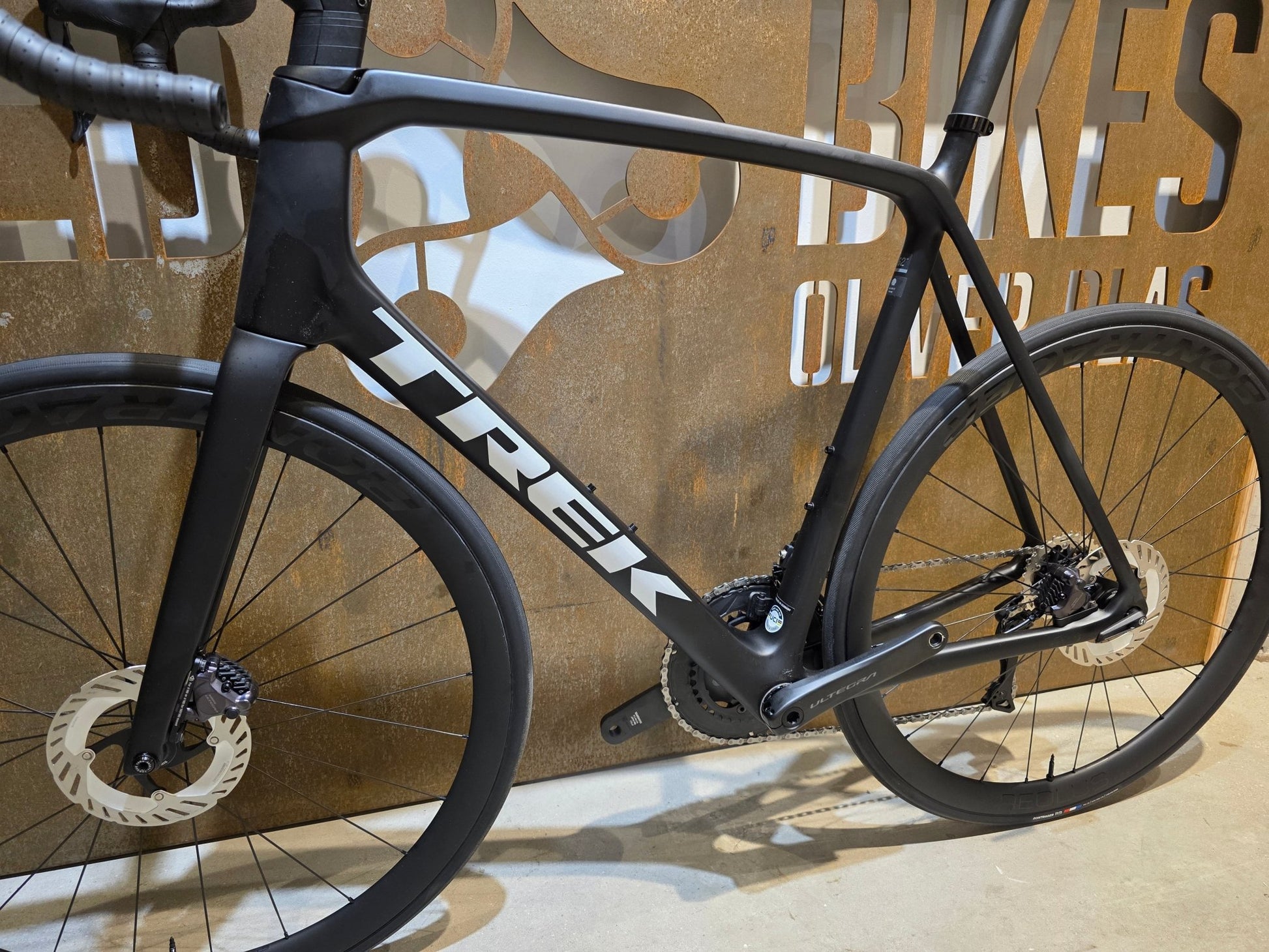 Rennrad von Trek, TREK EMONDA SL 7 / MATTE CARBON SMOKE / 62CM in variant_title vor USEDBIKES - OB.DE Hintergrund