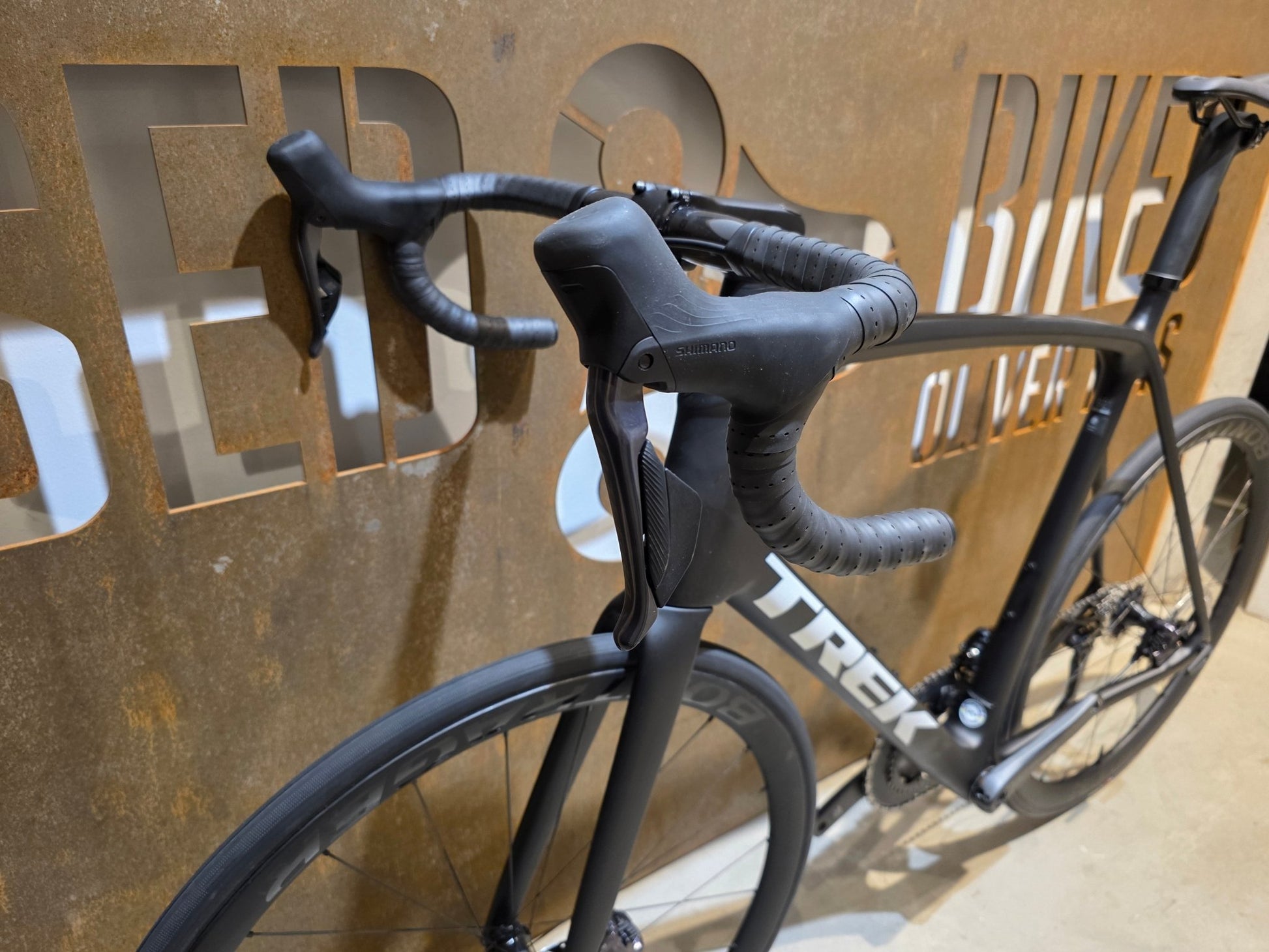 Rennrad von Trek, TREK EMONDA SL 7 / MATTE CARBON SMOKE / 62CM in variant_title vor USEDBIKES - OB.DE Hintergrund