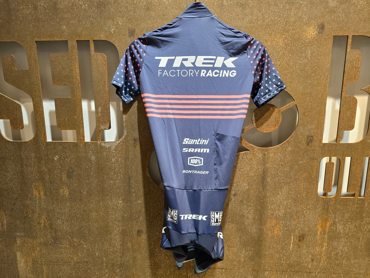 Damenbekleidung - TFR von Santini, TREK FACTORY RACING CX / CX SUIT SHORTSLEEVE SUPERLIGHT W. PKT / EINTEILER / DAMEN in variant_title vor USEDBIKES - OB.DE Hintergrund