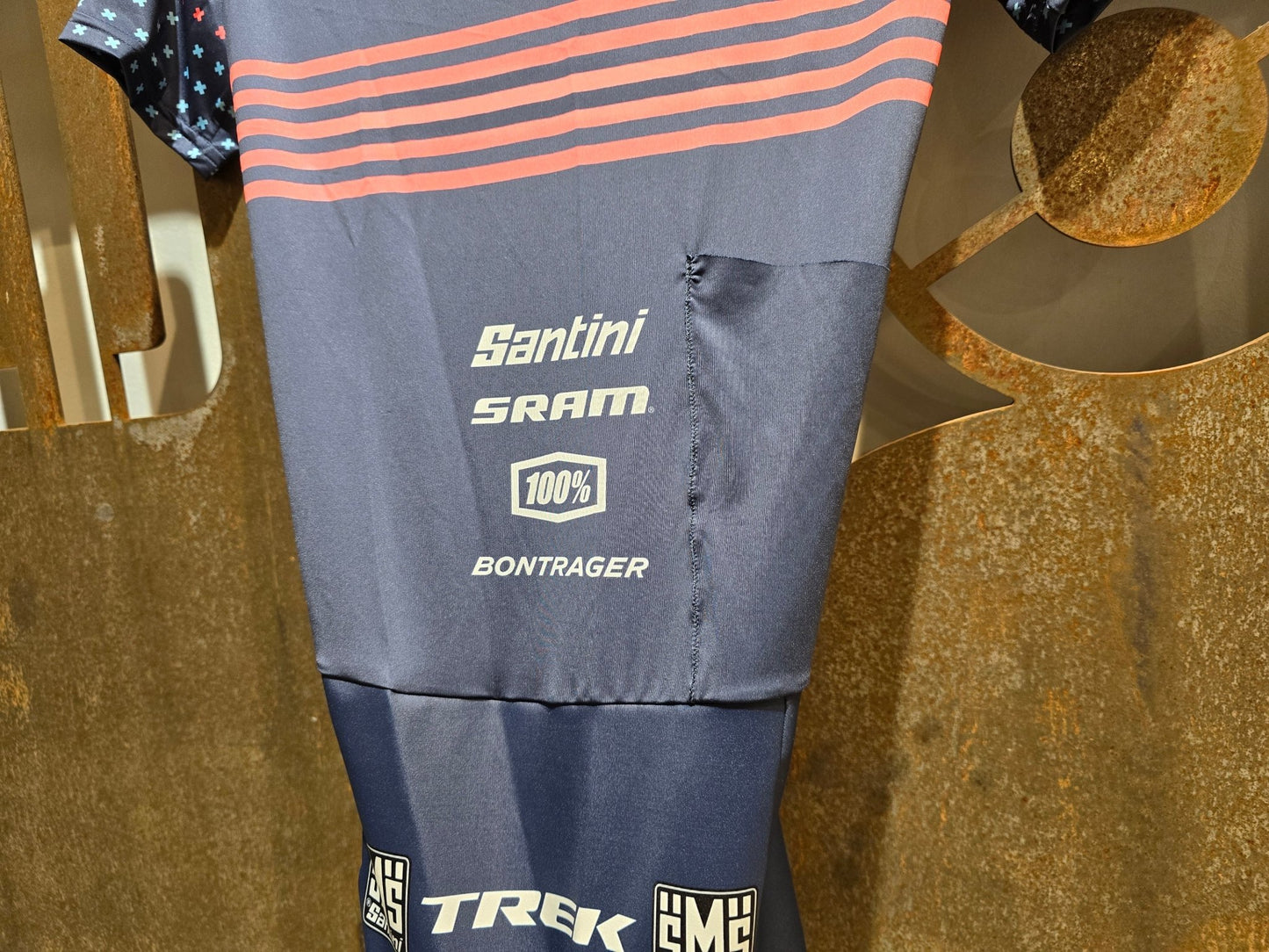 Damenbekleidung - TFR von Santini, TREK FACTORY RACING CX / CX SUIT SHORTSLEEVE SUPERLIGHT W. PKT / EINTEILER / DAMEN in variant_title vor USEDBIKES - OB.DE Hintergrund