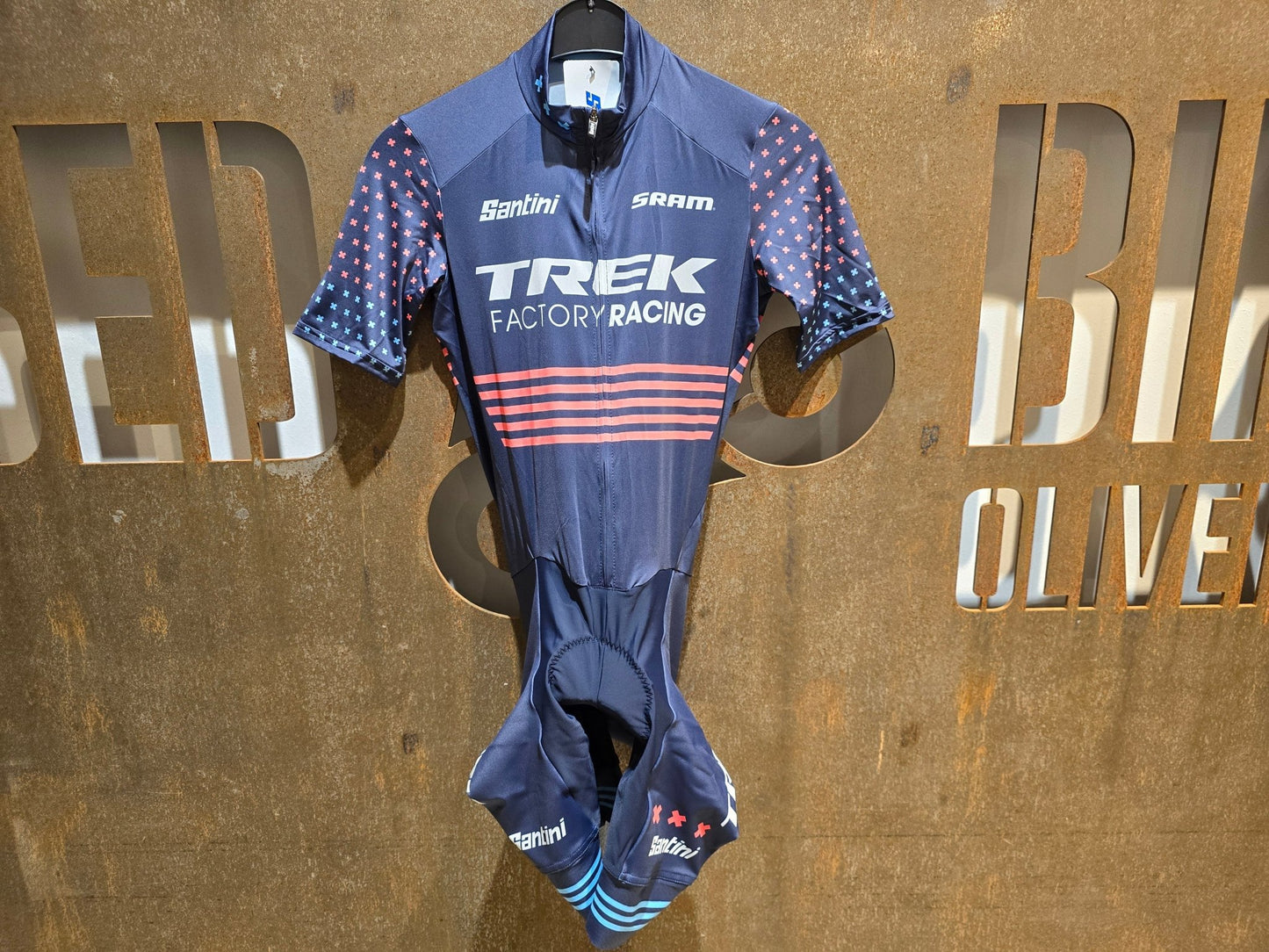 Damenbekleidung - TFR von Santini, TREK FACTORY RACING CX / CX SUIT SHORTSLEEVE SUPERLIGHT W. PKT / EINTEILER / DAMEN in variant_title vor USEDBIKES - OB.DE Hintergrund