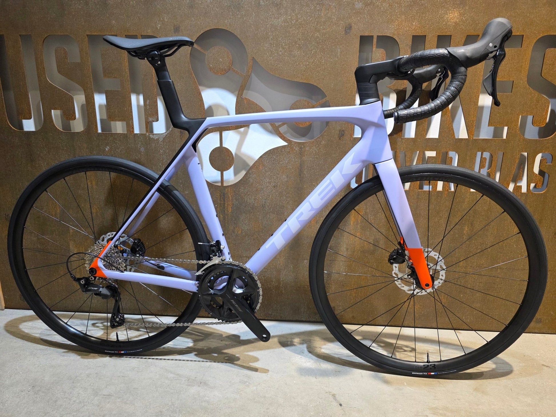 Rennrad von Trek, TREK MADONE SL 5 GEN 8 / MATTE LAVENDER HAZE / L vor USEDBIKES - OB.DE Hintergrund