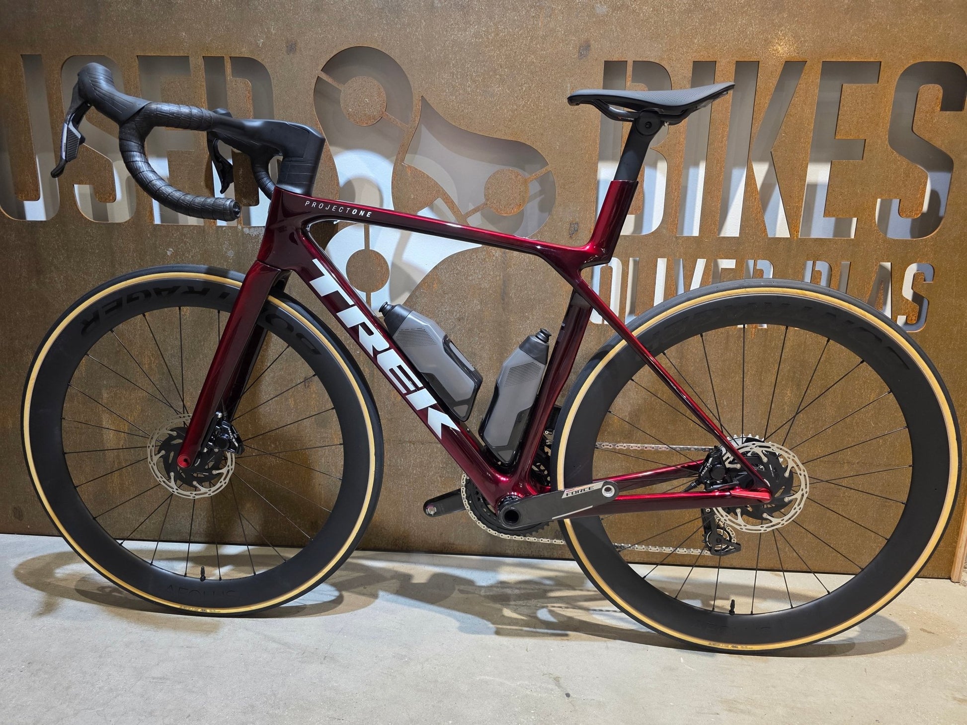 Rennrad von Trek, TREK MADONE SLR 7 AXS MY 2026 / CARBON RED SMOKE / M vor USEDBIKES - OB.DE Hintergrund