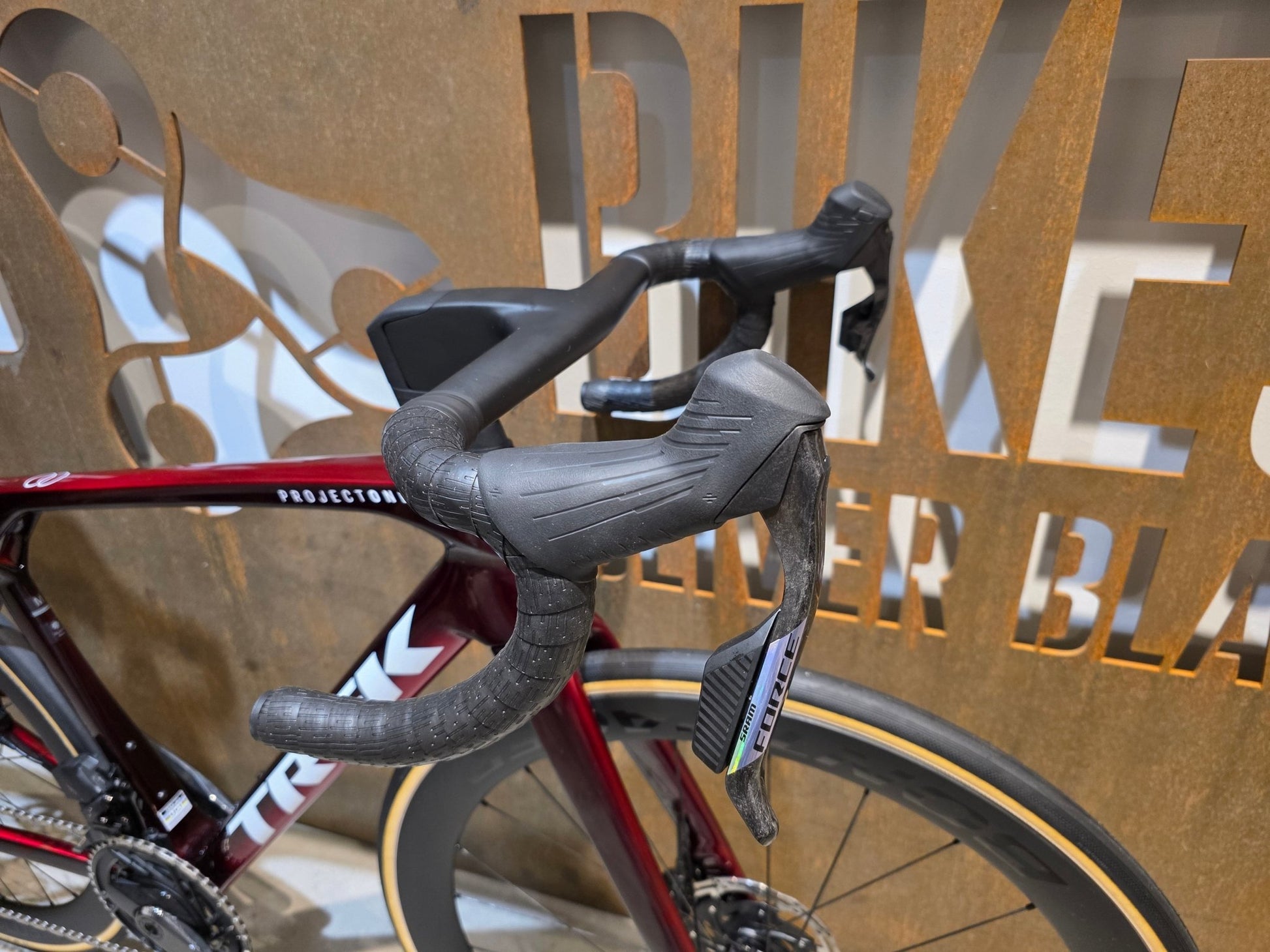 Rennrad von Trek, TREK MADONE SLR 7 AXS MY 2026 / CARBON RED SMOKE / M vor USEDBIKES - OB.DE Hintergrund