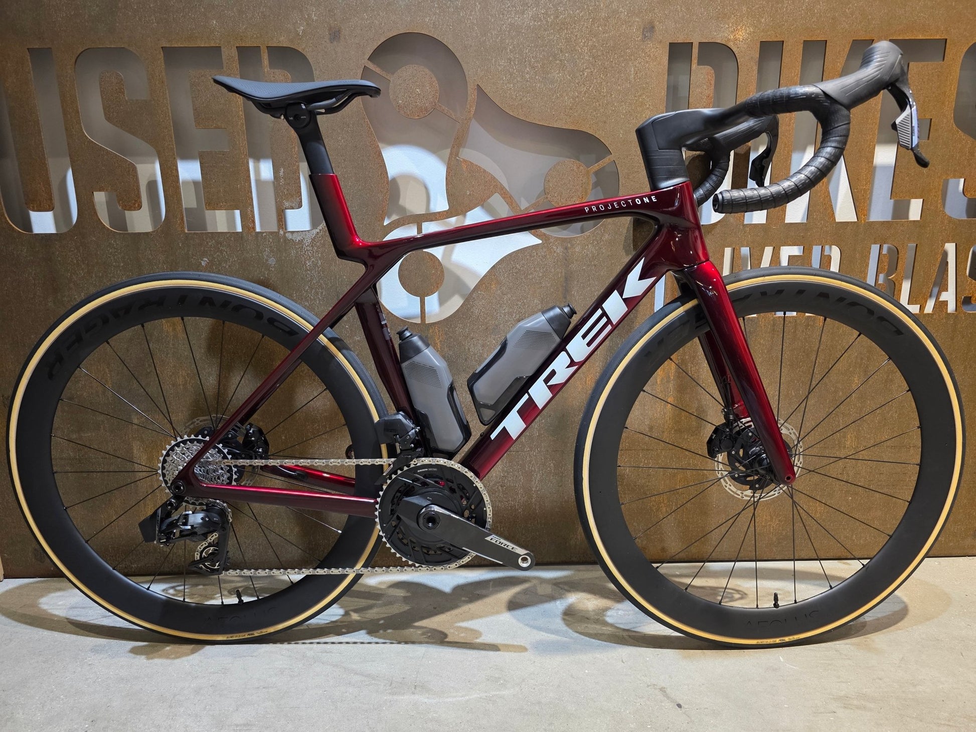 Rennrad von Trek, TREK MADONE SLR 7 AXS MY 2026 / CARBON RED SMOKE / M vor USEDBIKES - OB.DE Hintergrund